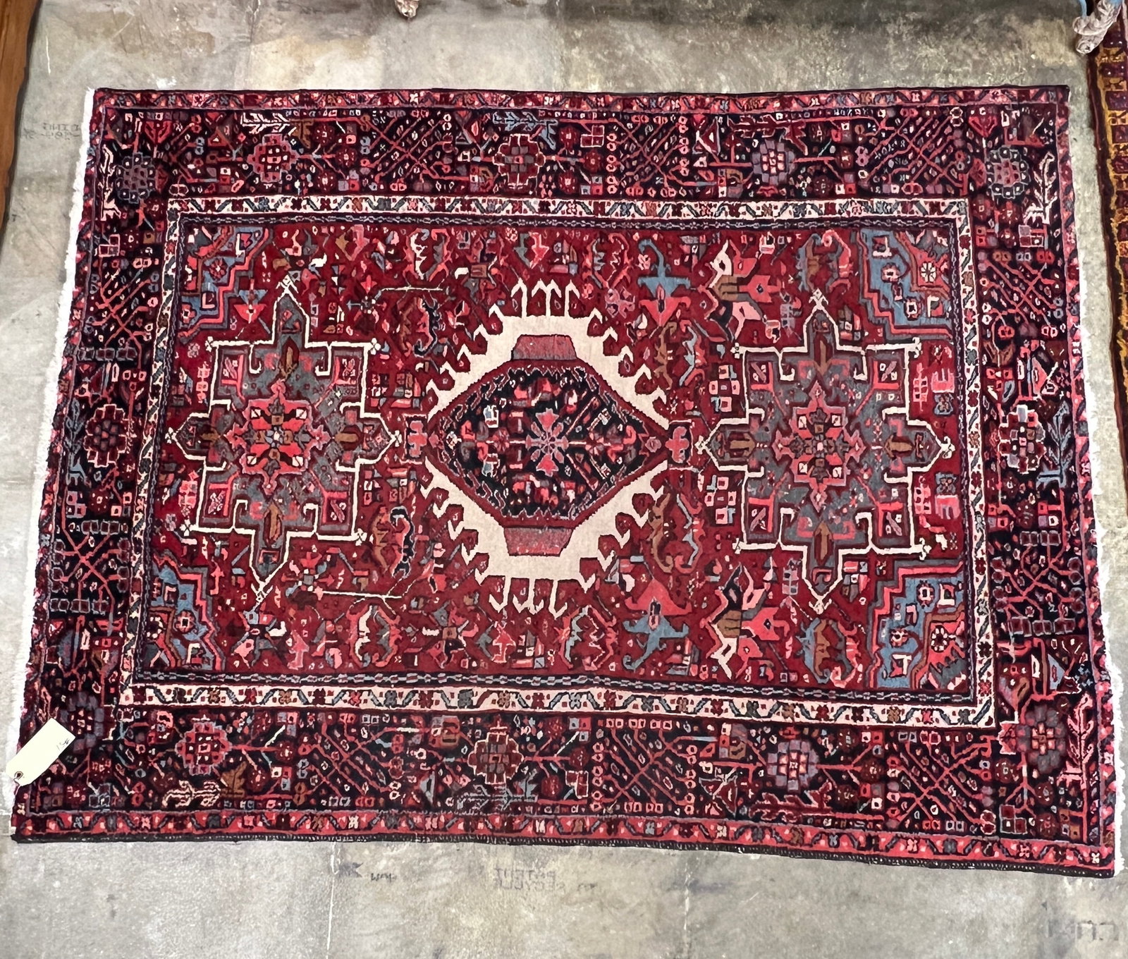 Antique Karaja Persian Hand Tied Wool Rug: Antique Persian hand knotted rug that features geometric borders, a floral field in pinks, creams, greens, and browns in very good condition. It measures 75" X 57.5".