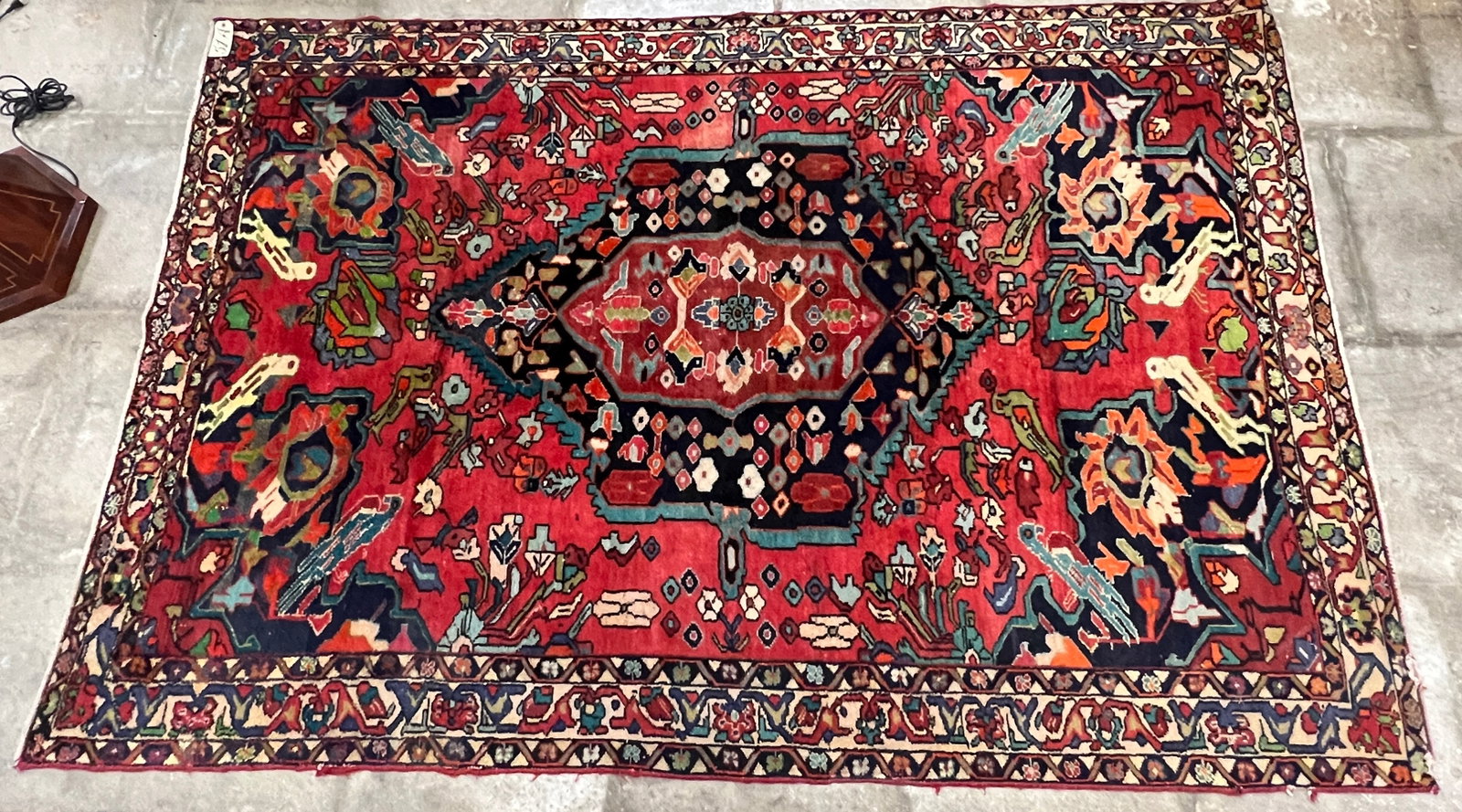 1800s Persian Heriz Rug: A rare 1800s Persian Heriz room size rug with bold floral central medallion, birds, flowers and a 4 edged border. This stunning hand woven rug is in rich shades of umber, black, cream, blue and green 