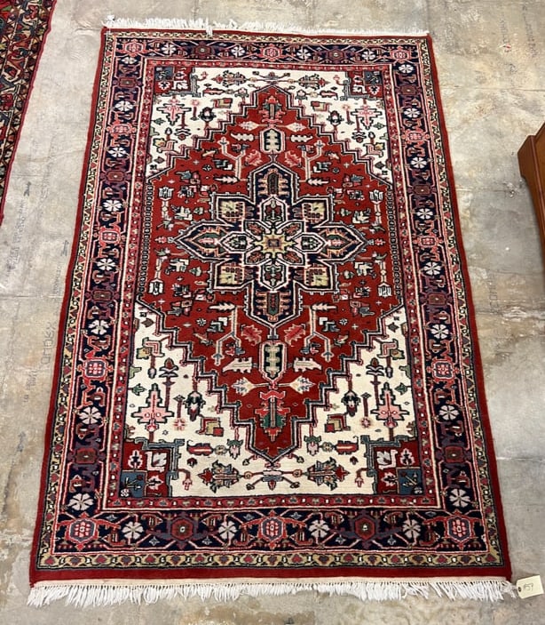 Persian Heriz-Serapi Wool Rug: Persian Heriz-Serapi wool rug in excellent condition. It retains its fringes and features geometric central field often found in Heriz-Sarapi rugs. The rug features reds, creams, blues, and navy.