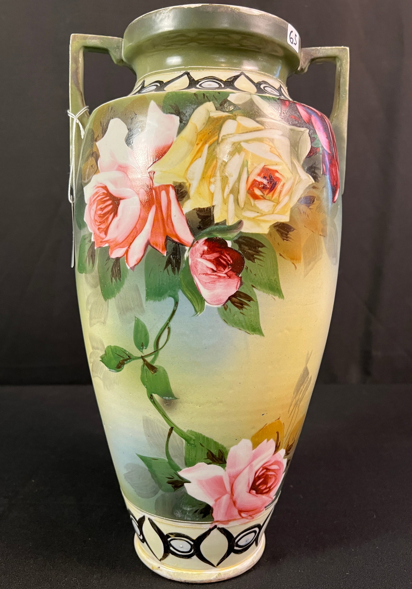 Hand Painted Nippon Vase Depicting Roses: A Nippon hand painted and double-handled vase of important size. Vase dates to the turn of the century and is elaborately painted with roses in red, pink, and yellow. It measures 16" tall.