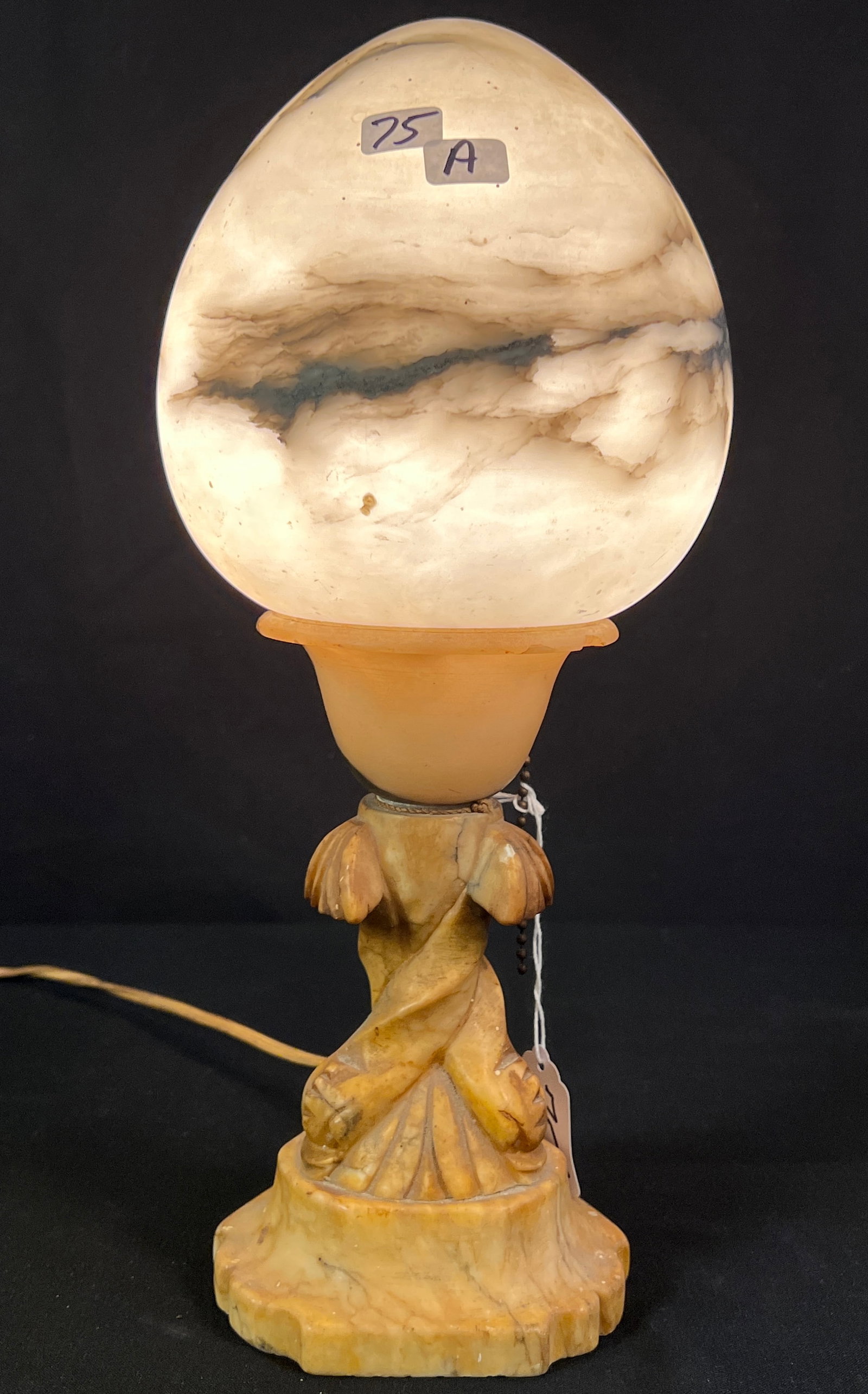 Alabaster Table Lamp: An egg-shaped dome alabaster table lamp with carved base. In working condition, this lamp measures 14.5" tall.