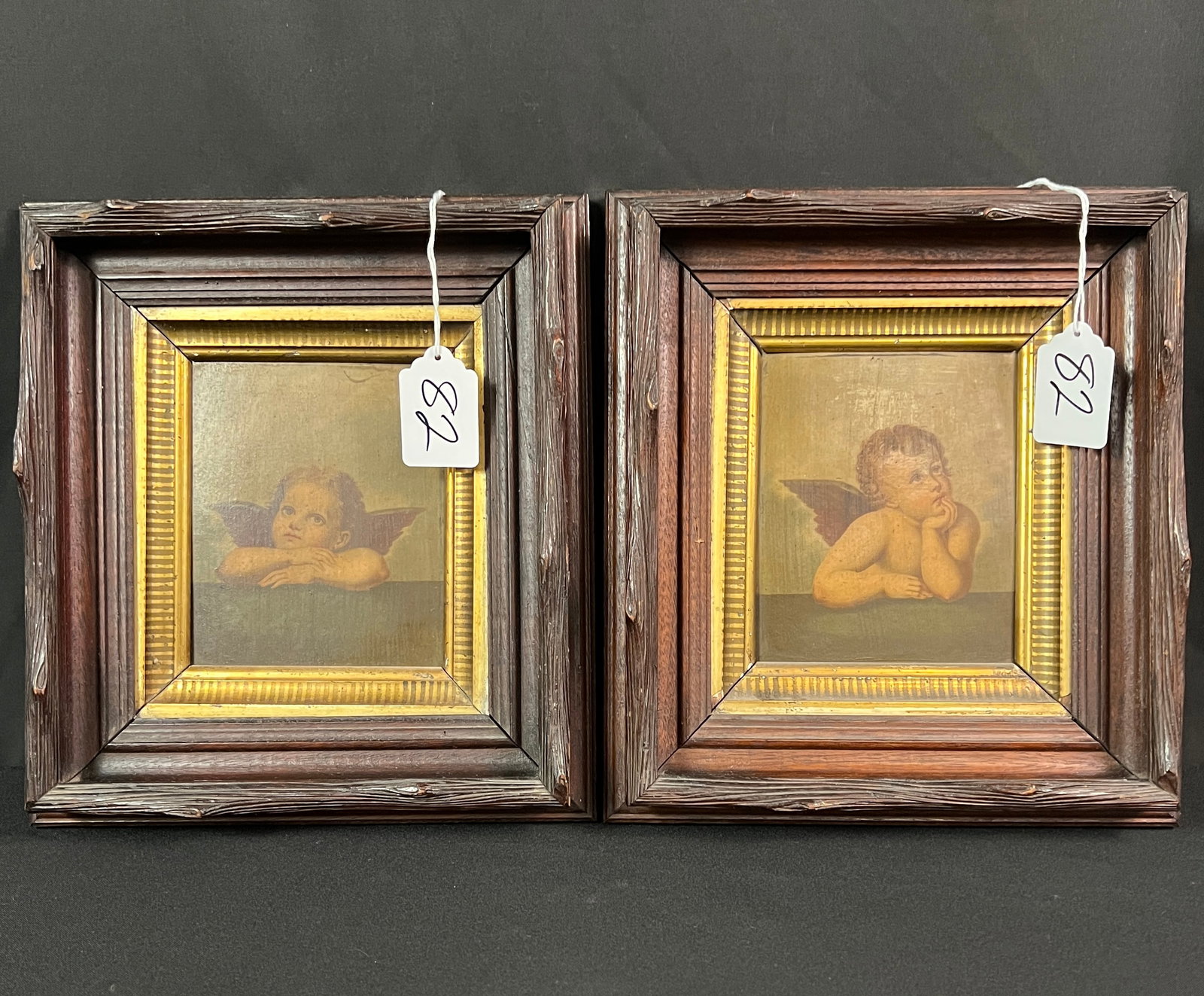 Pair of Oil on Board Paintings of Cupids c.19th: A pair of oil on board paintings of cupids in hand carved 19th century frames, unsigned in good condition. They each measure 12" tall X 10" across, framed.