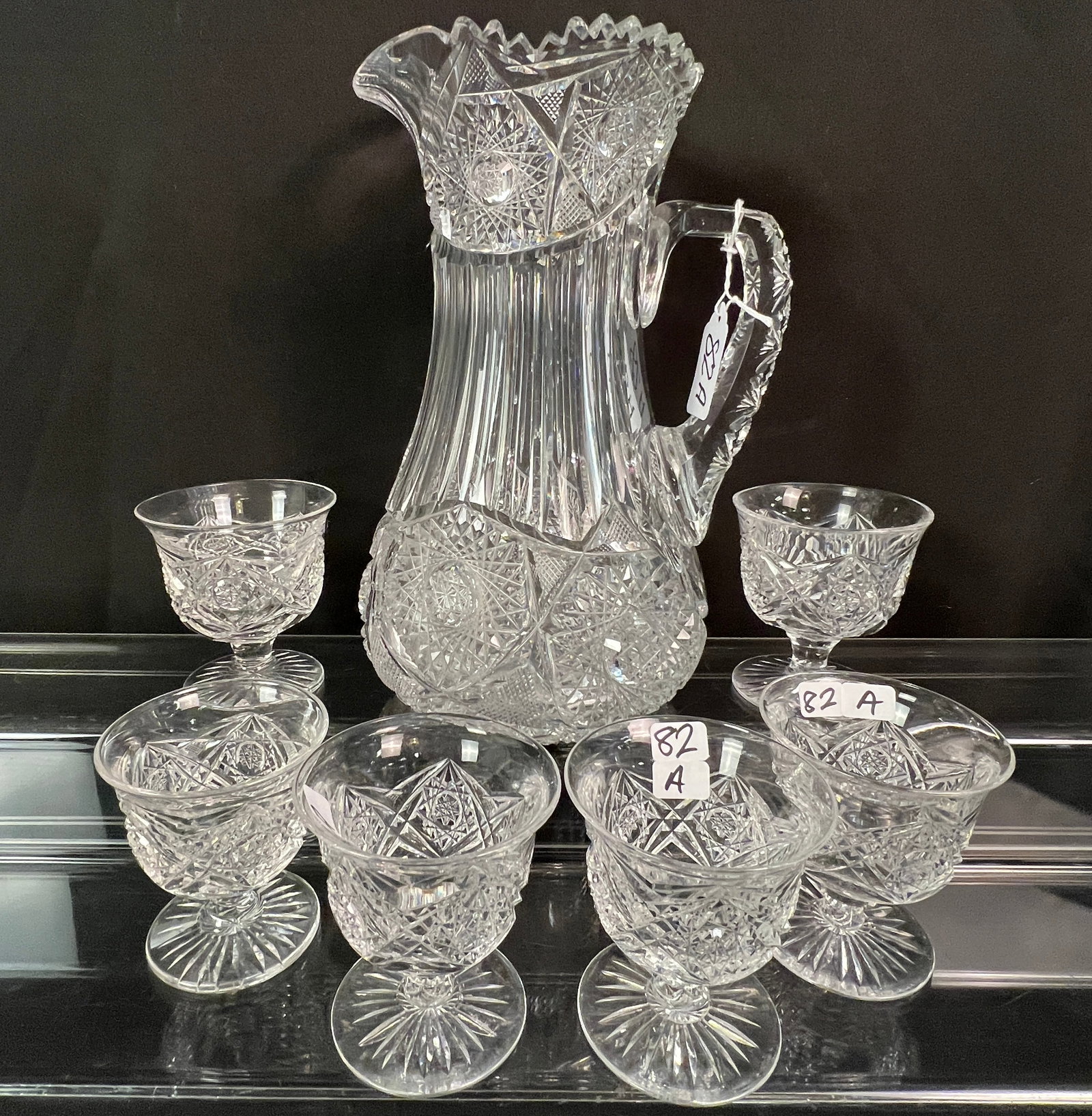Victorian Cut Glass Pitcher w/ 6 Tumblers: A Victorian wheel and brilliant cut glass, cross hatched crystal pitcher (10" tall X 7" round) along with 6 matching tumblers (3.5" tall X 3" across). In excellent condition.