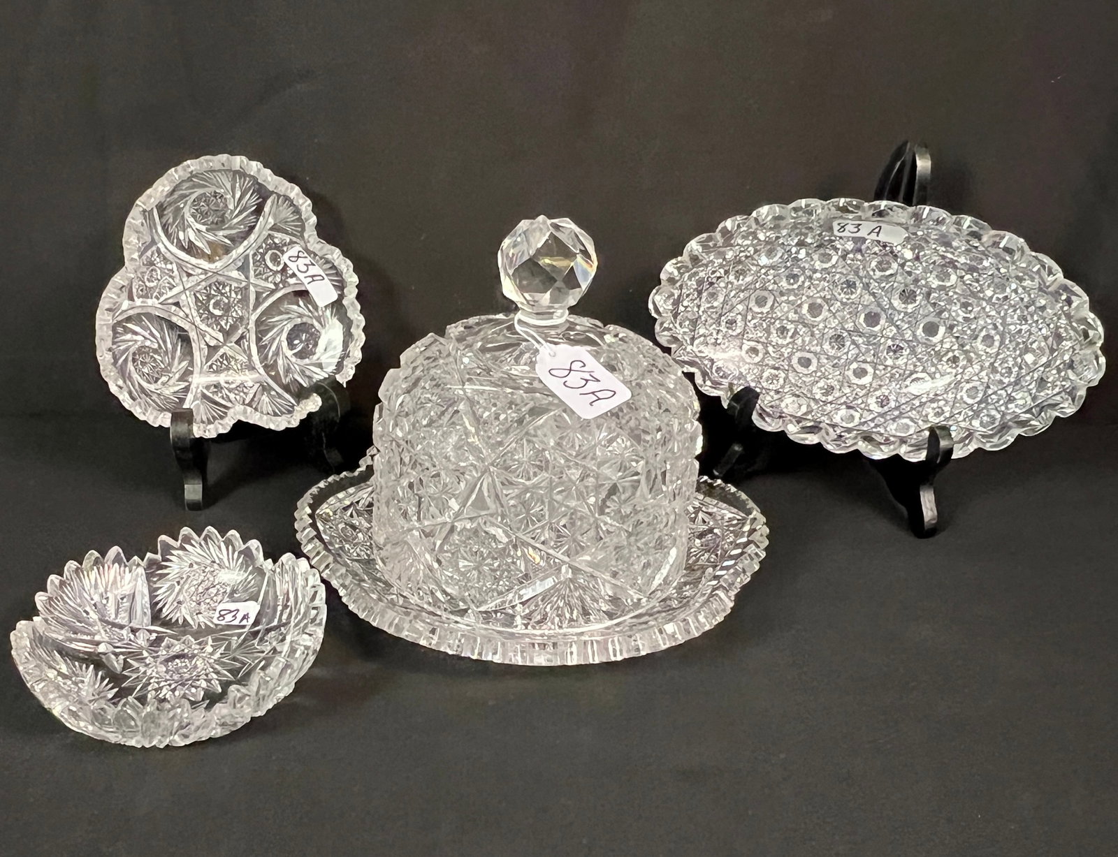 Brilliant Cut Crystal Covered Butter and More: A stunning brilliant and wheel cut crystal covered butter (6.5" tall X 9" round). Along with 3 small shallow serving bowls to include a popcorn and cross hatch cut relish dish (8.5" long X 5" across) 