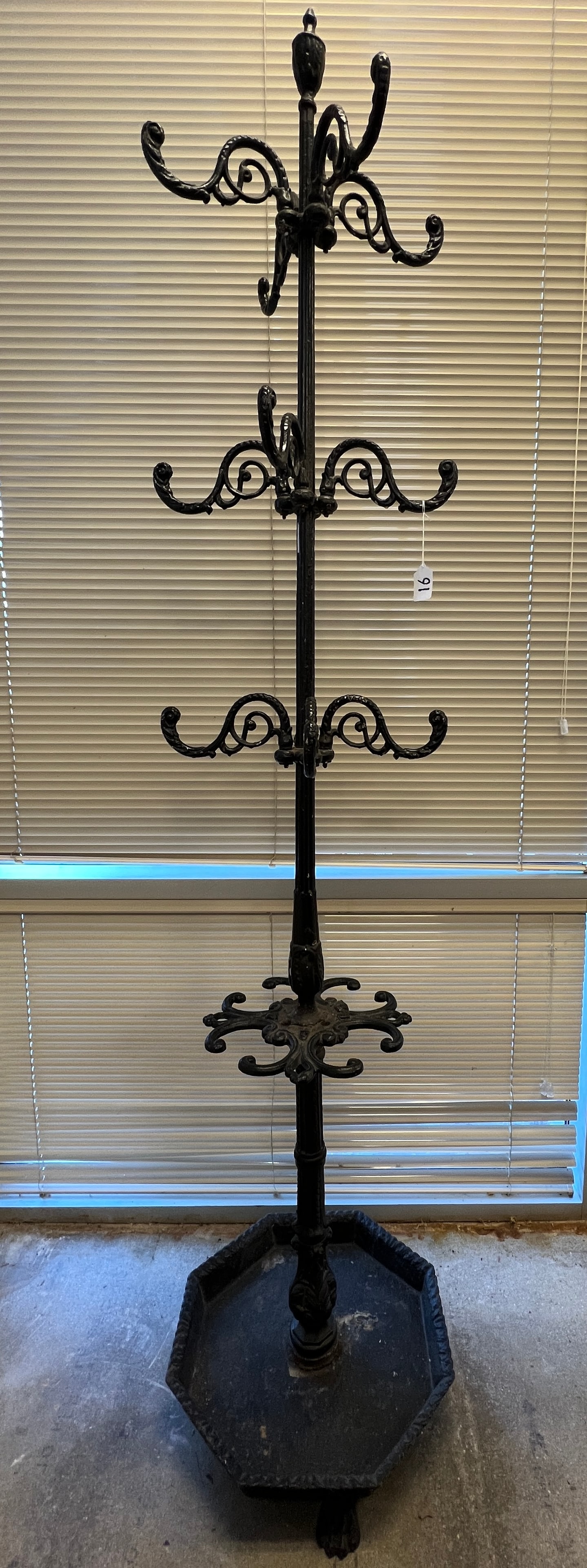 Victorian Cast Iron Hall Tree: A tall ornate cast iron free standing hat rack/ umbrella stand in very good condition. It features 12 adjustable hooks, octagonal umbrella base with paw feet. This came from the Plankinton Hotel in Mi