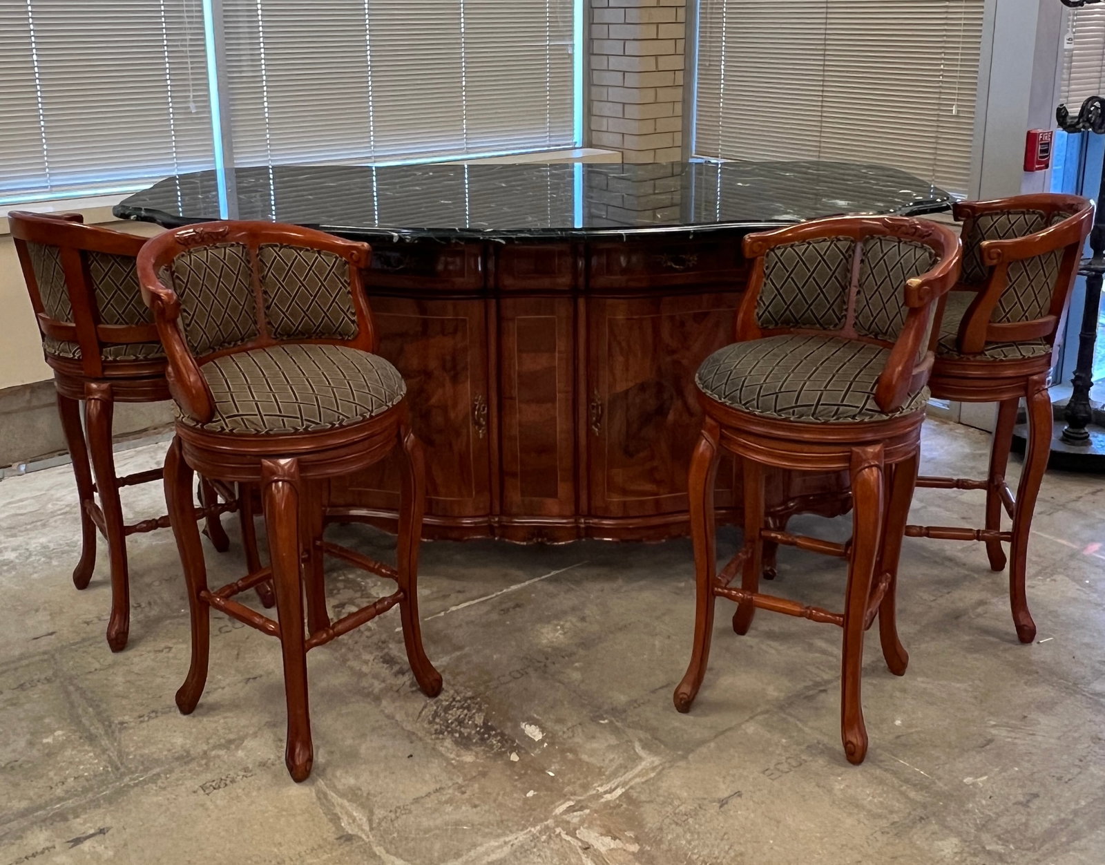 French Style Oversized Marble Top Bar with Four Chairs: A large French serpentine flamed mahogany marble top bar that features bombe style sides with string inlay, elaborate bronze hardware, 4 drawers, 4 cabinet door storage, and 4 swivel chairs with