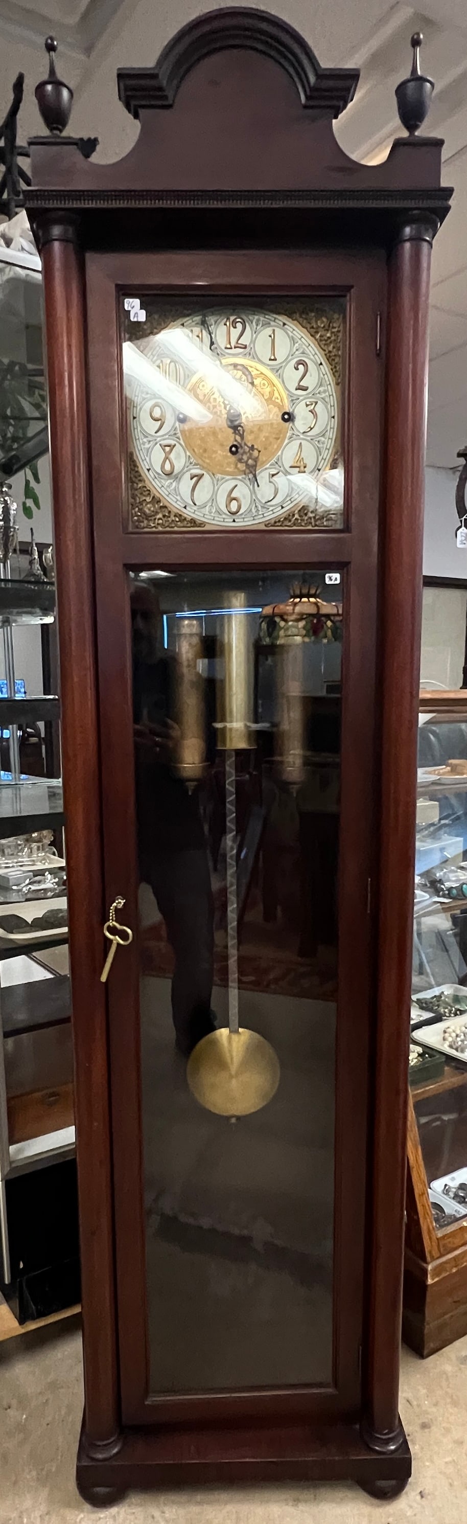1920s Mahogany Grandmothers Clock: A 1920s mahogany grandmothers clock featuring a pillared front and turned finial top. Case is in excellent condition and clock appears to be complete however does not keep time, needs to be serviced.