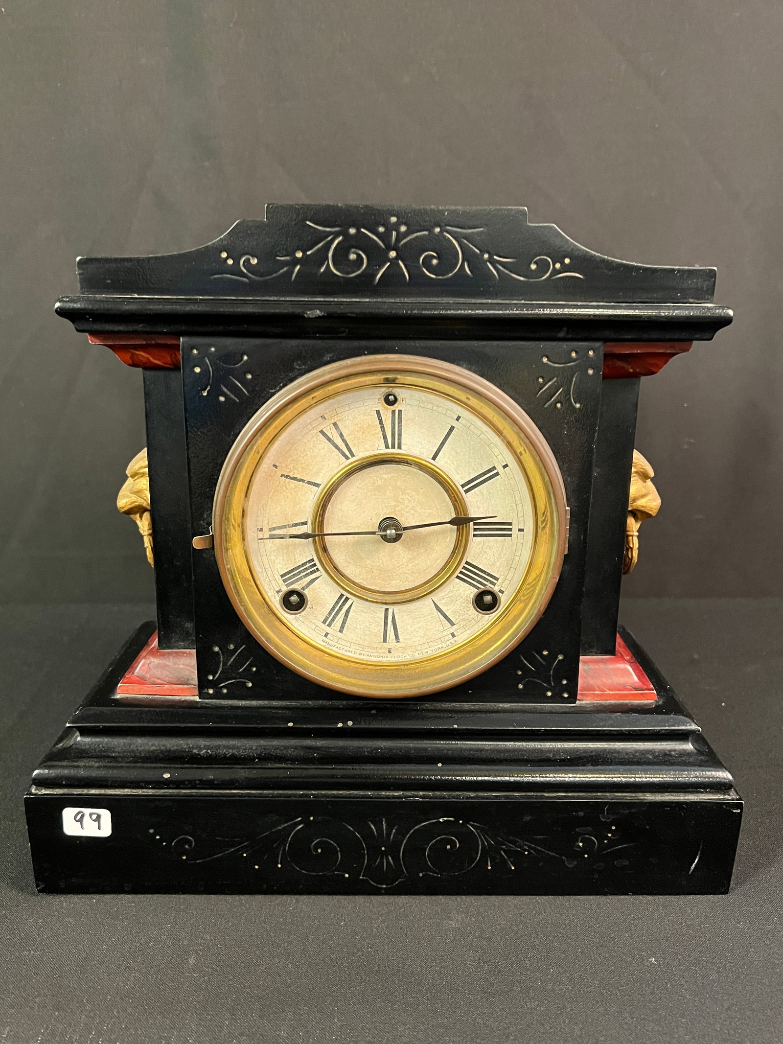 New Haven Walnut Victorian Parlor Clock: A Victorian New Haven walnut parlor clock that features back painted glass door, winged cupids, mirrored sides, elaborate carvings and finials. It measures 25.5" tall X 17" across X 5" deep.