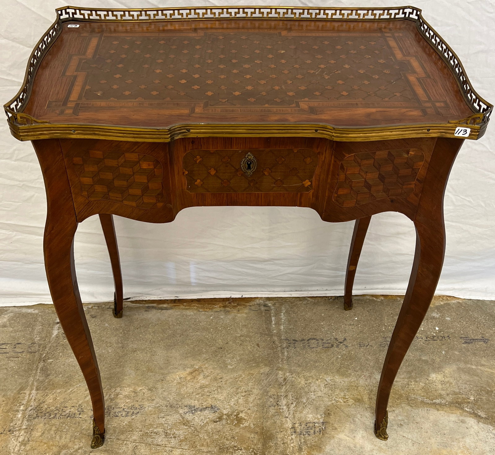 Early French Marquetry and Ormolu Desk C. 1900-1920: A French marquetry inlaid ladies writing desk that features serpentine legs with fancy ornate brass ormolu foot covers, slide back top central drawer, marquetry sides, front , back and top, and brass