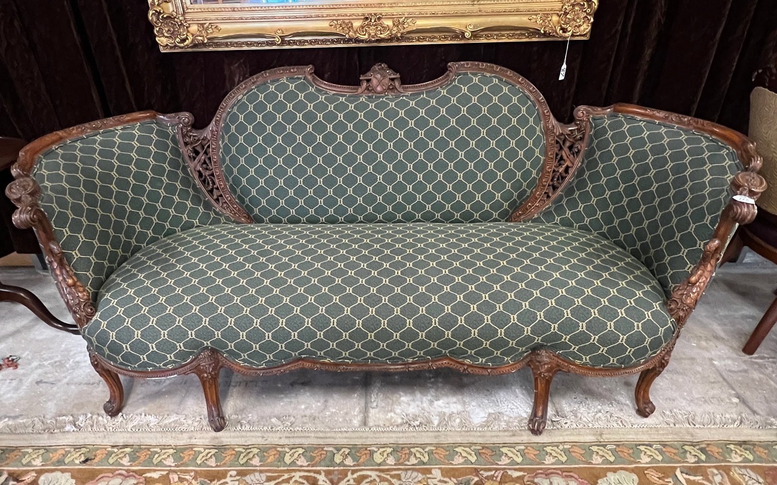 1920s Elaborately Pierced Carved Sofa: A profusely carved mahogany upholstered sofa c.1920's that features swan carved arm fronts, shell feet, violin and horn carved back vents, a top central violin and horn carved crest , scrolled