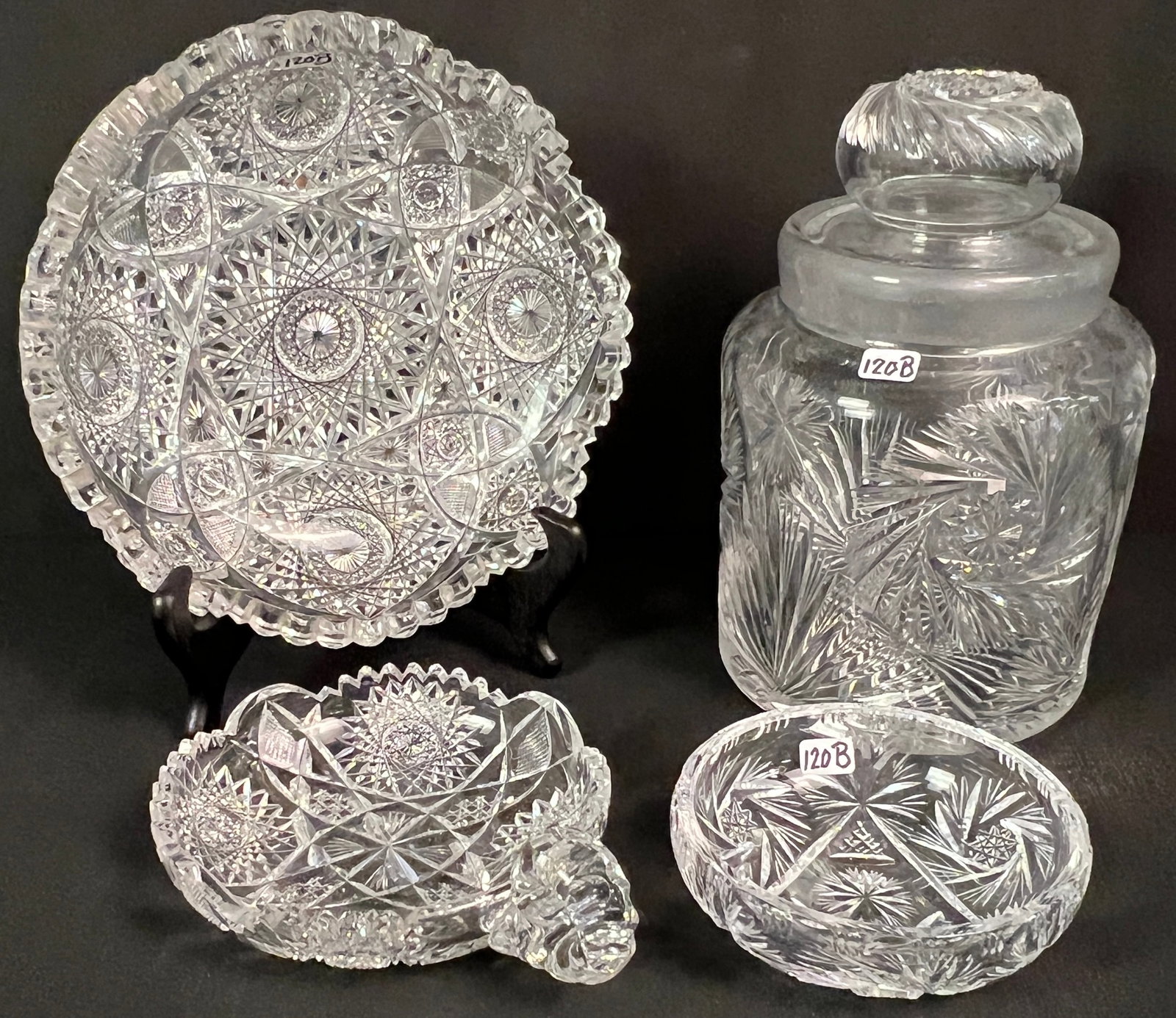 Large Group of Brilliant Cut Crystal: A large group of brilliant cut crystal to include a pinwheel cut covered jar (9.5" tall X 6" round), a profusely cut and sawtooth edge bowl (2.5" tall X 9" round), a small shallow bowl (5" round), and