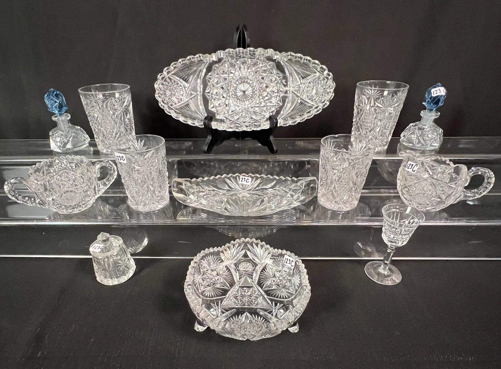 Group of Cut Crystal: A group of cut crystal to include 4 matching tumblers, a matching creamer and sugar, a relish dish in the shape of a canoe, a Victorian sawtooth relish dish, 2 perfume bottles with blue stoppers, mini