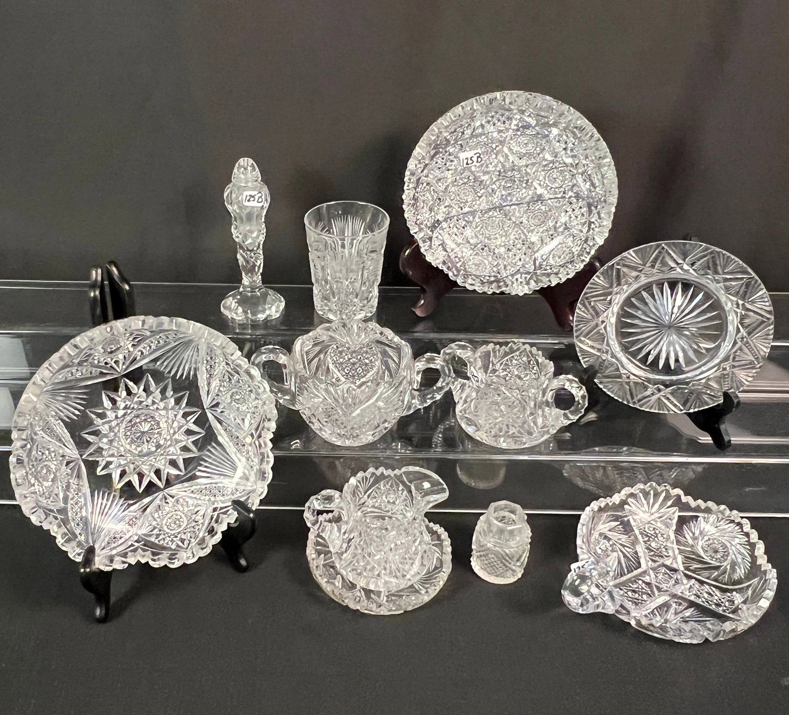 Large Group of Brilliant Cut Crystal: A large group of brilliant cut crystal to include a brilliant and wheel cut nappy, a brilliant and wheel cut shallow bowl with saw teeth, a wheel cut crystal creamer and sugar, a large cut double hand