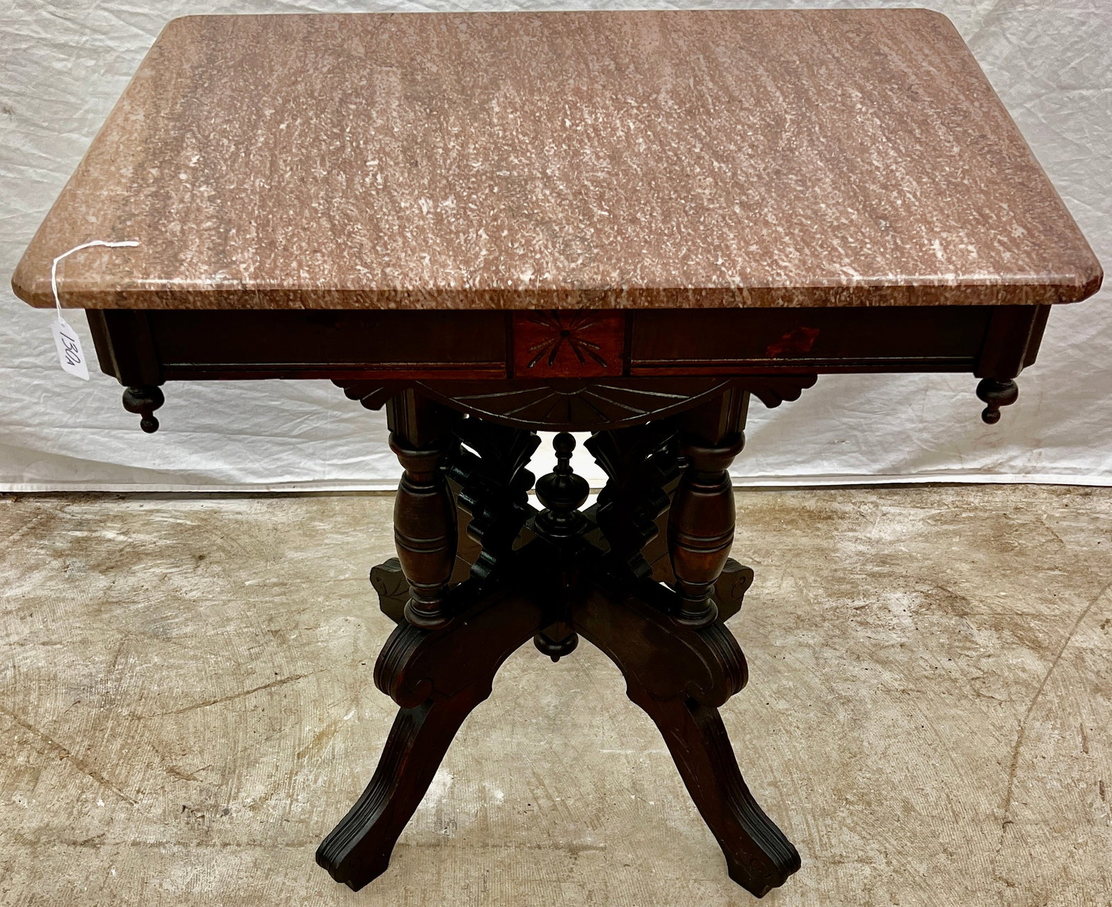 Victorian Marble Top Parlor Table: A Victorian walnut marble top parlor table with fancy leaf decorations, turned posts, in original finish and as is condition. It measures 30" tall X 30.5" across X 21" deep.