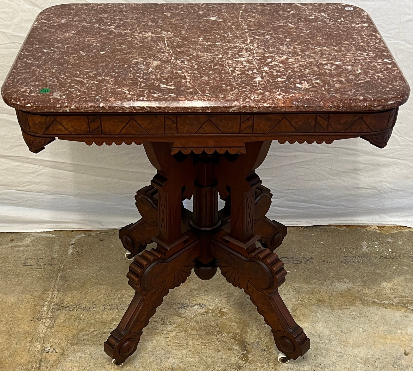 Victorian Mahogany Marble Top Parlor Table c. 1880: Victorian marble top carved mahogany parlor table that features burled wood legs and apron, carved corners and legs, on casters with a burgundy marble top. In excellent condition in original finish, i