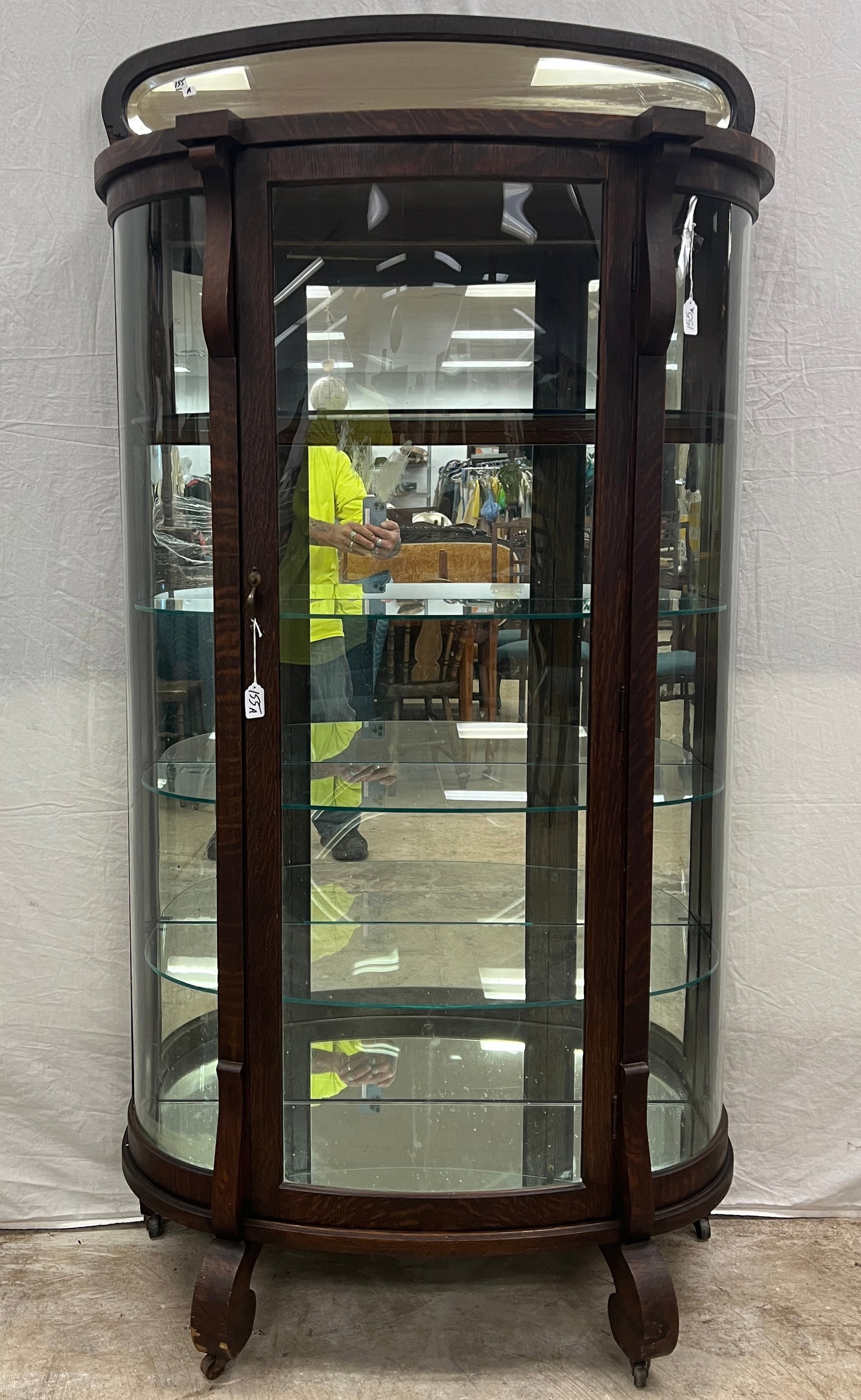 Oak Curved Glass China Cabinet: An oak mirrored top and back, curved glass china cabinet, with glass adjustable shelves, in original finish. This nice china cabinet measures 72" tall X 35" across X 15" deep. In fair condition.
