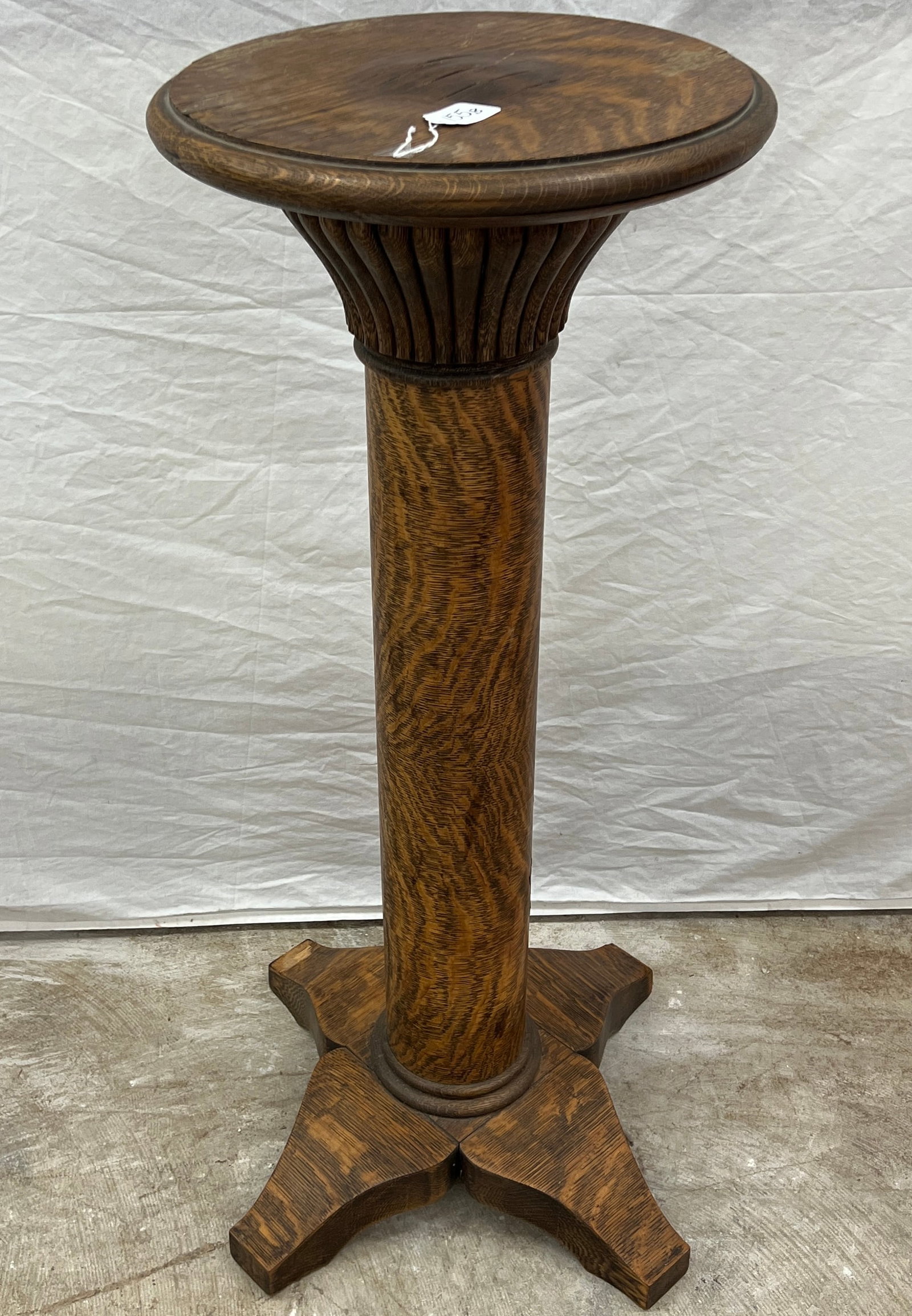 Oak Plant Pedestal: An oak pillared base plant pedestal, minor marring to top but otherwise in great condition. It measures 36" tall X 14" round.