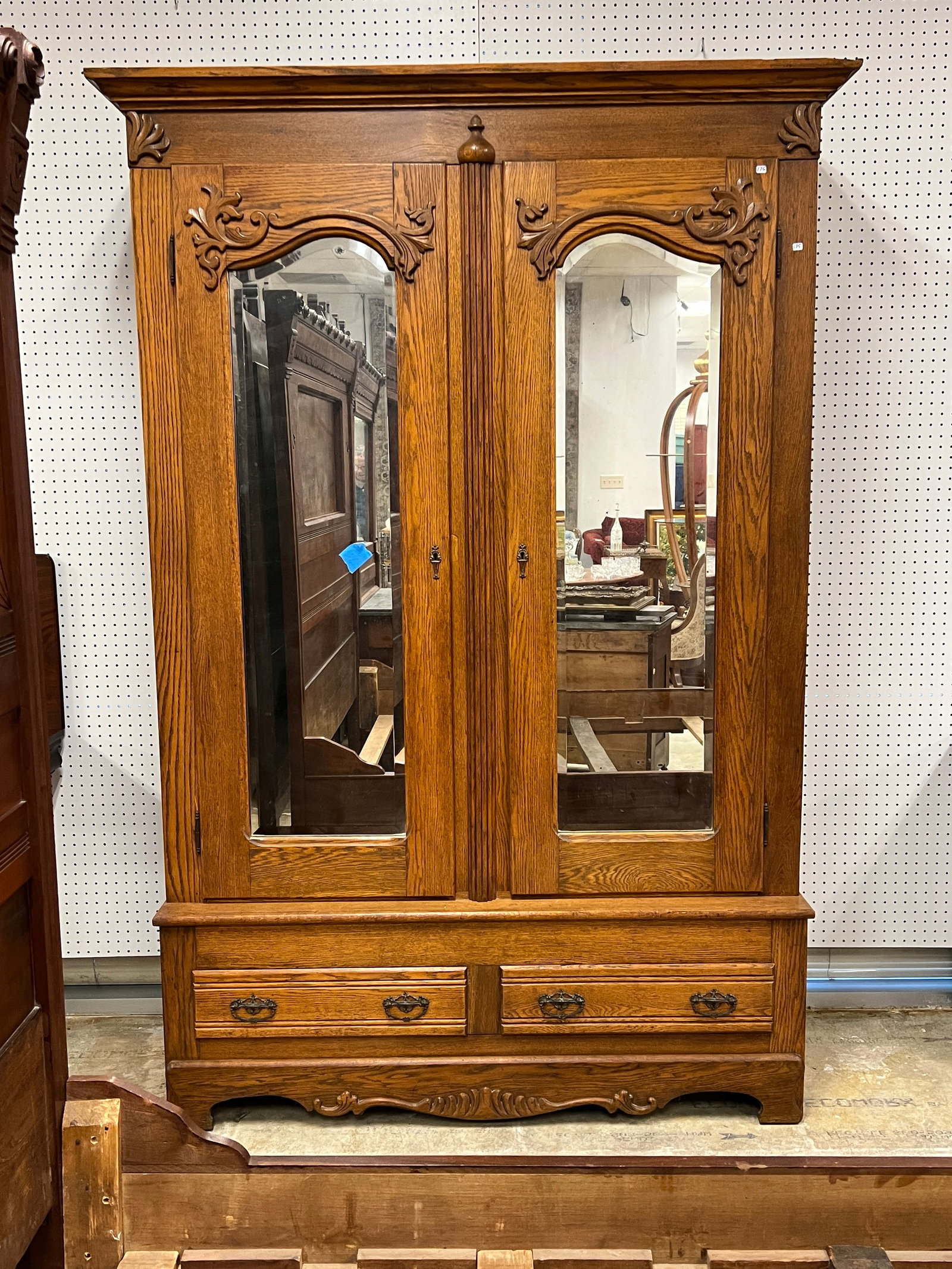 Victorian Carved Mirrored Wardrobe c.1880's: A Victorian oak knock apart double mirrored door wardrobe features applied carvings, beveled mirrored doors over 2 drawers in original finish.
