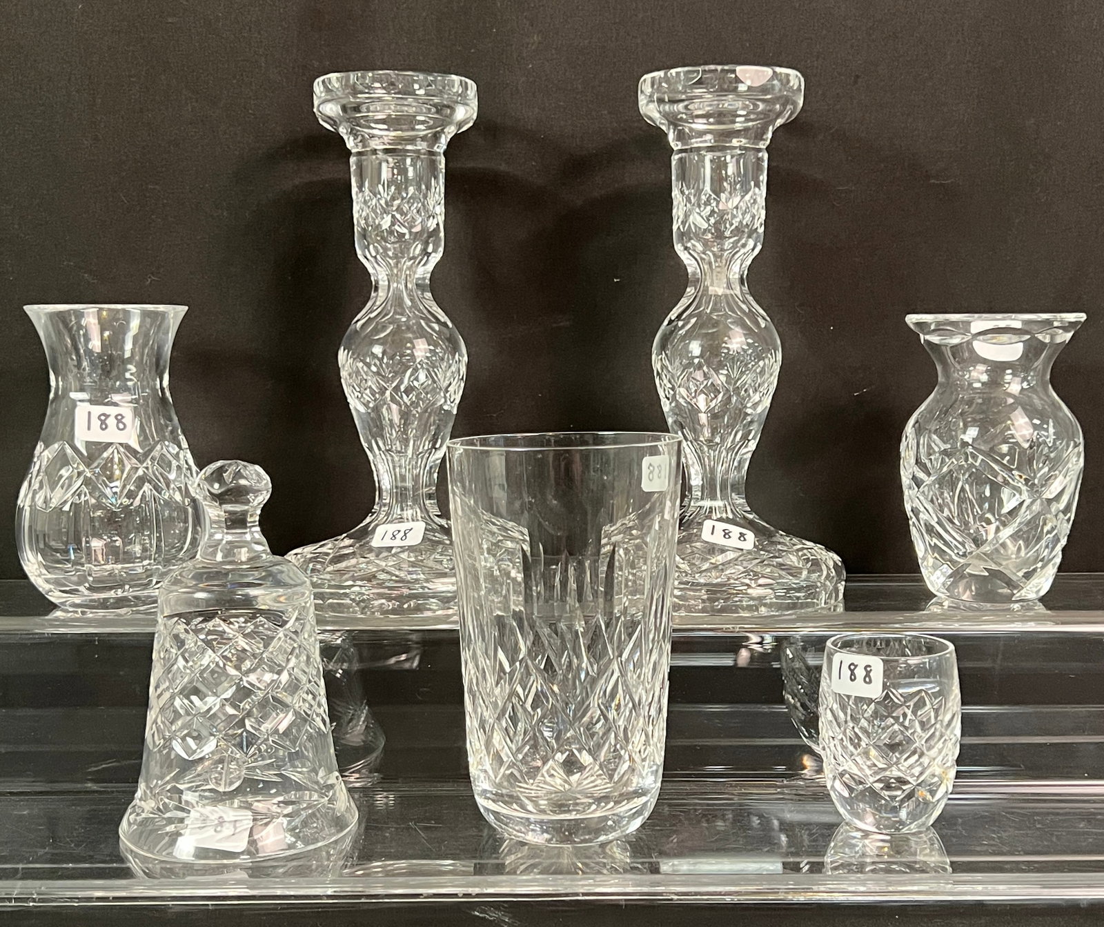 Waterford Candle Holders and Group of Assorted Waterford Smalls: A pair of Waterford candle stick holders, measuring 7.5" tall X 4" across. To also include a group of small Waterford pieces including 2 small bud vases, a toothpick holder, a single water glass and