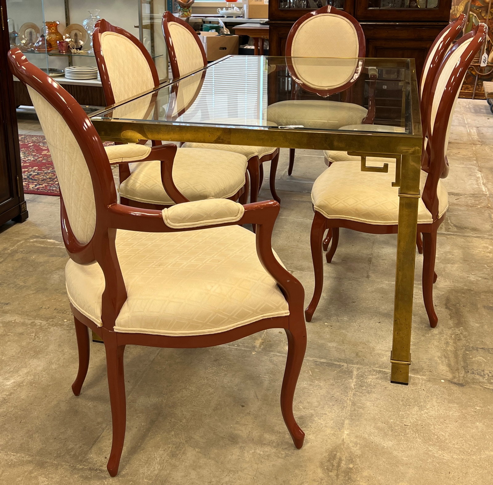 Brass Glass Top Chinoiserie Dining Table and Chairs: A solid brass glass top Chinoiserie dining table with beveled glass top along with a set of 6 lacquered upholstered dining chairs with cream silk diamond jacquard upholstery. Table measures 29" tall