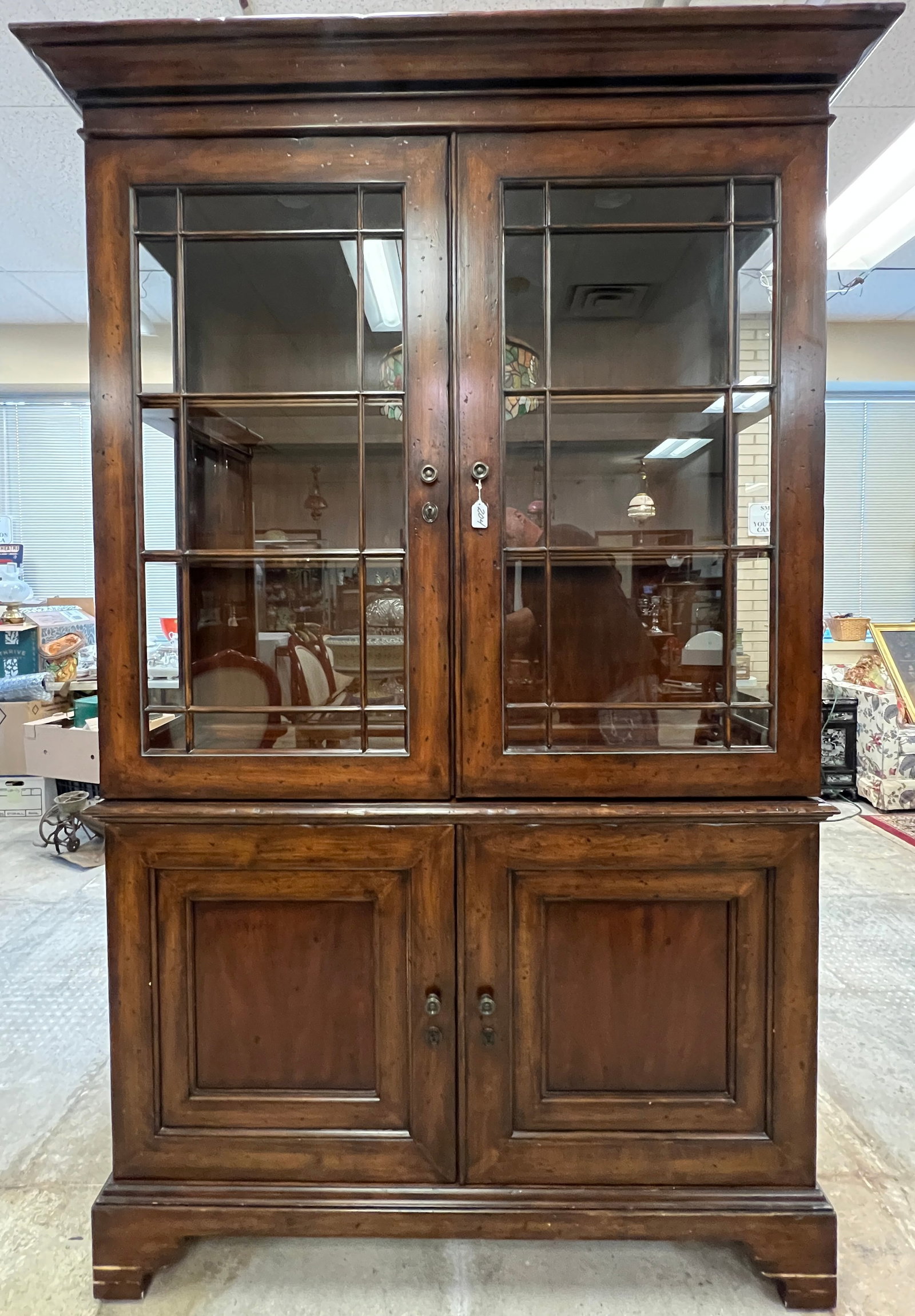 Contemporary Country Pine Illuminated Display Cabinet: A contemporary 2 part dark stained country pine double door display cabinet in very good condition that features glass shelves and double door bottom.