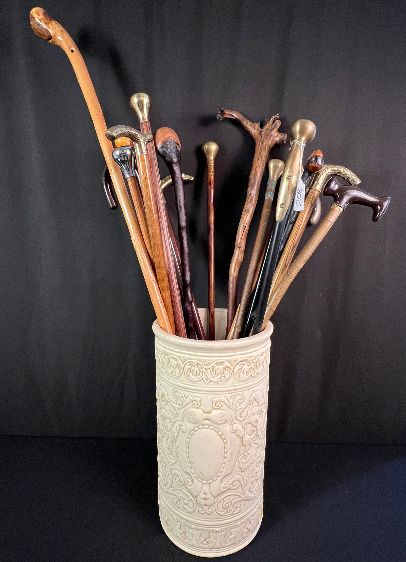 Group of Assorted Walking Canes: A group of 17 walking canes to include shillelagh, fancy brass handled, nickel handled, carved, horse head handle, sterling, and others. In good condition. With a stoneware umbrella stand that has bee