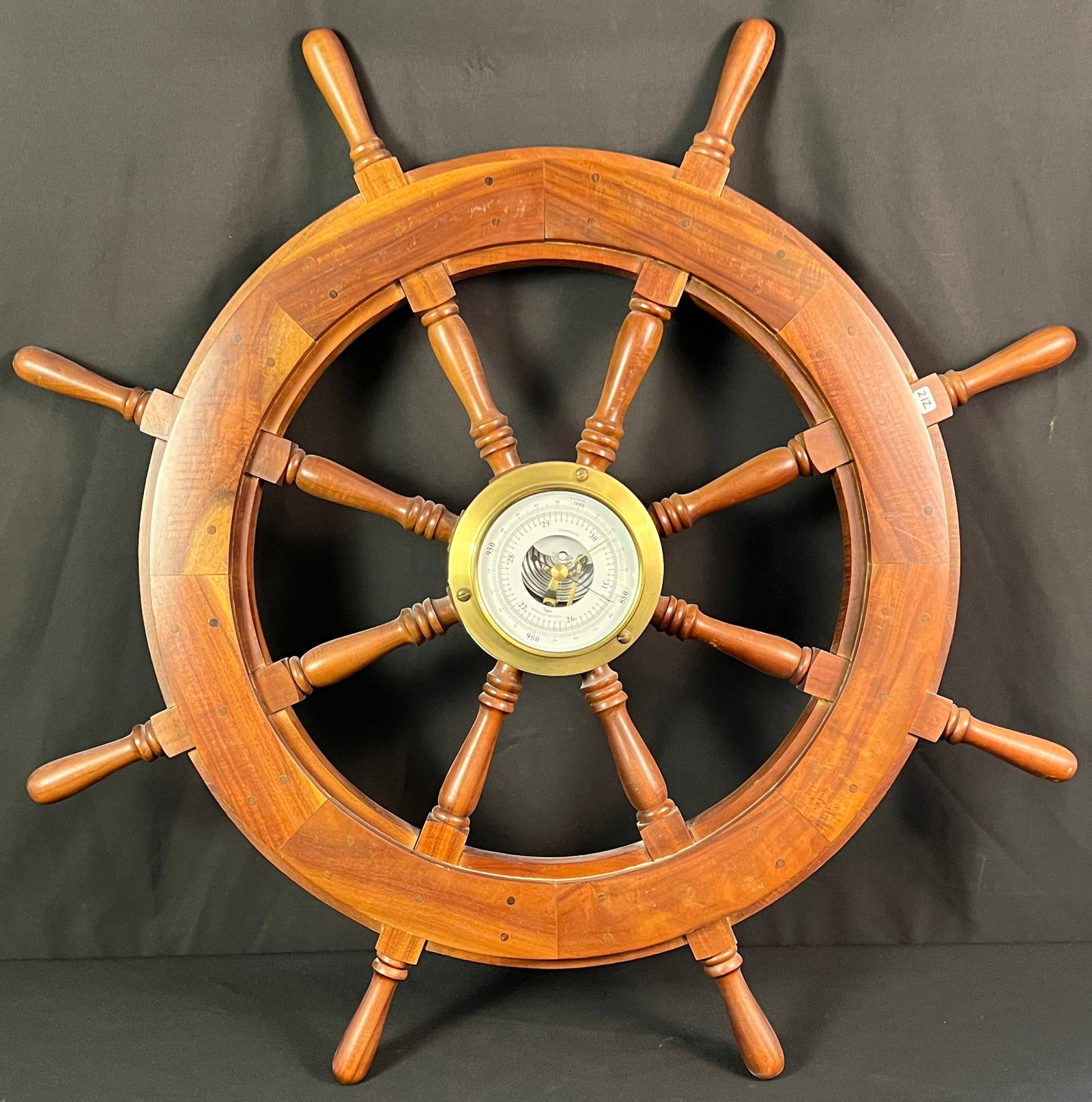 Ship Wheel Barometer: A mid-century wooden ship wheel with a barometer set in the middle. Measures 36" around X 5" deep.