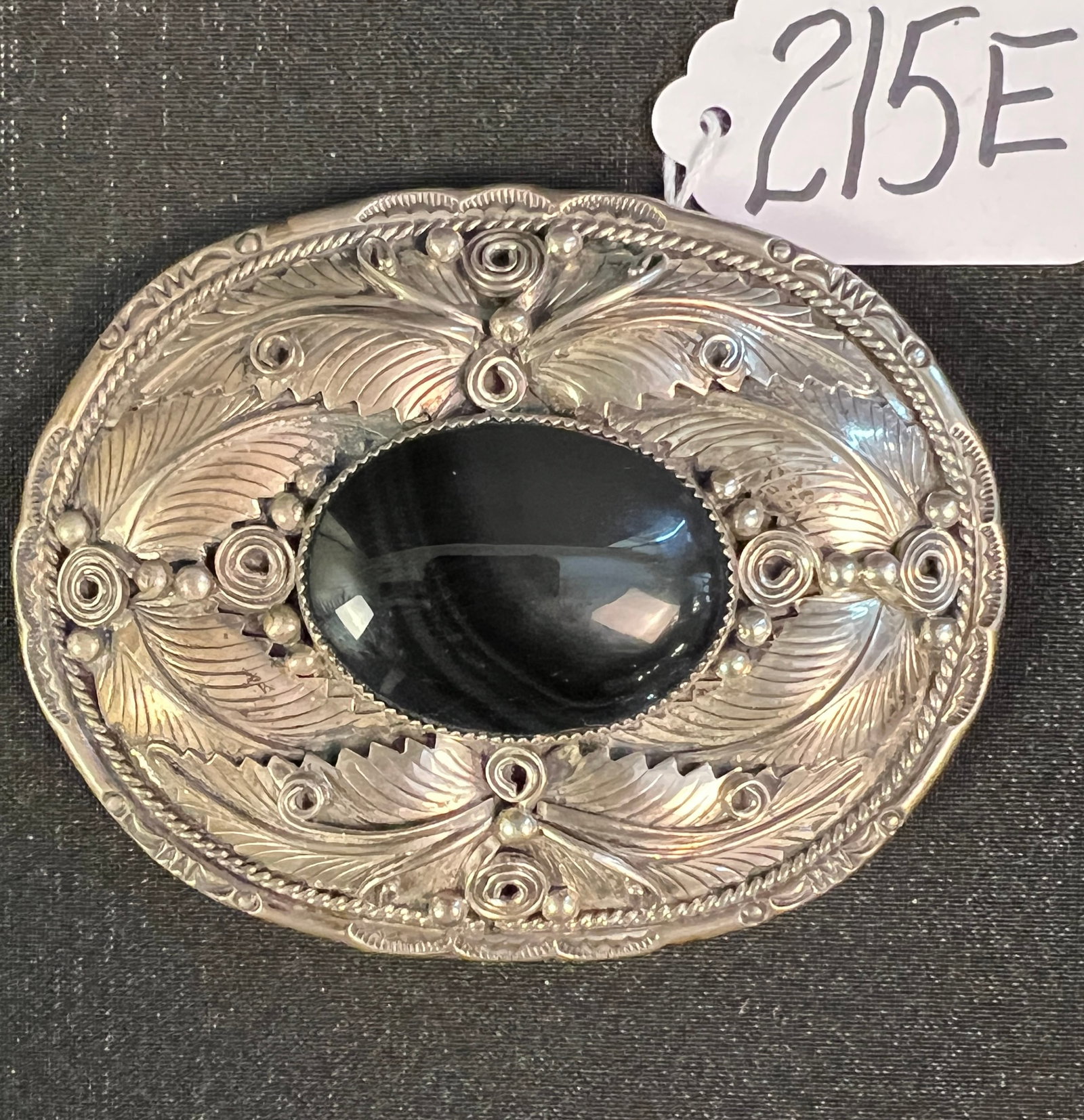 Sterling Silver Large Belt Buckle: A sterling silver elaborately filigreed Southwest Indian belt buckle with jet stone center, signed sterling and initialed 'AM'. With stone, it weighs 86.10g, and is in excellent condition.