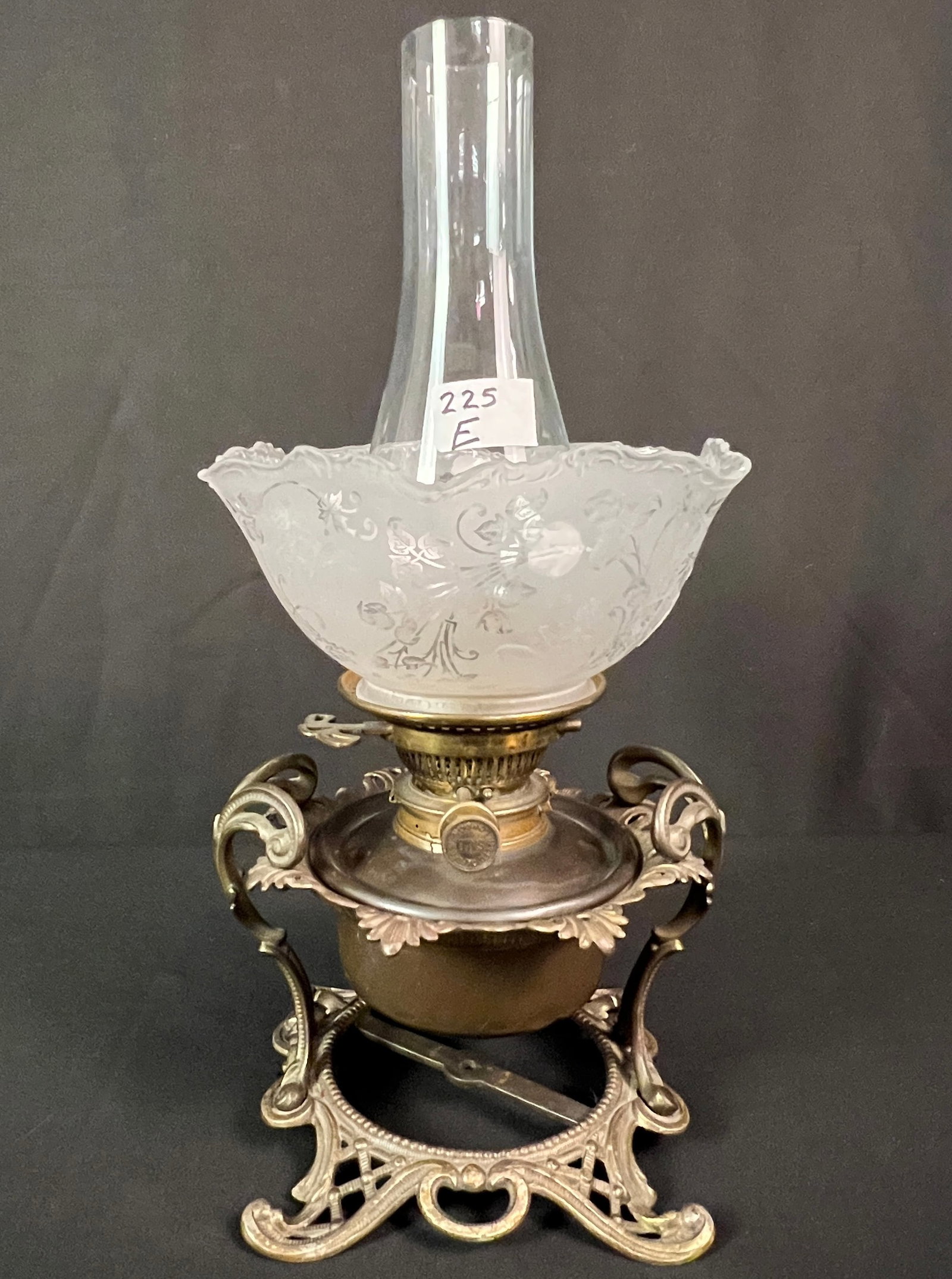 Paddle Wheel Boat Oil Lamp: An elaborate oil lamp with an elaborate iron filigreed base with floral acid cutback shade. It was purportedly out of the USS America paddlewheel boat that ran on the Mississippi River. This upper est