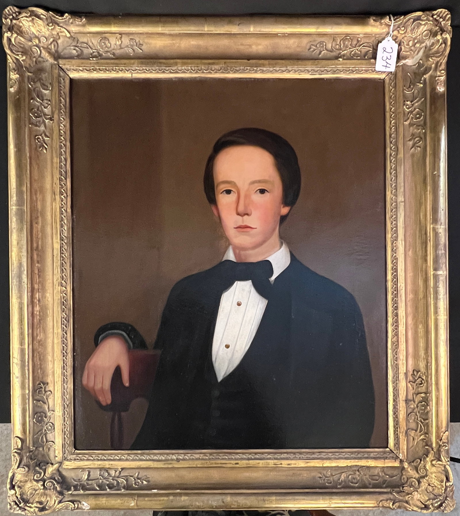 18th Century Portrait of Young Man: An 19th century portrait of a young man in a black bowtie in its original golf leaf frame in great condition with small loss to frame in upper right corner. This portrait measures 35" tall X 30"