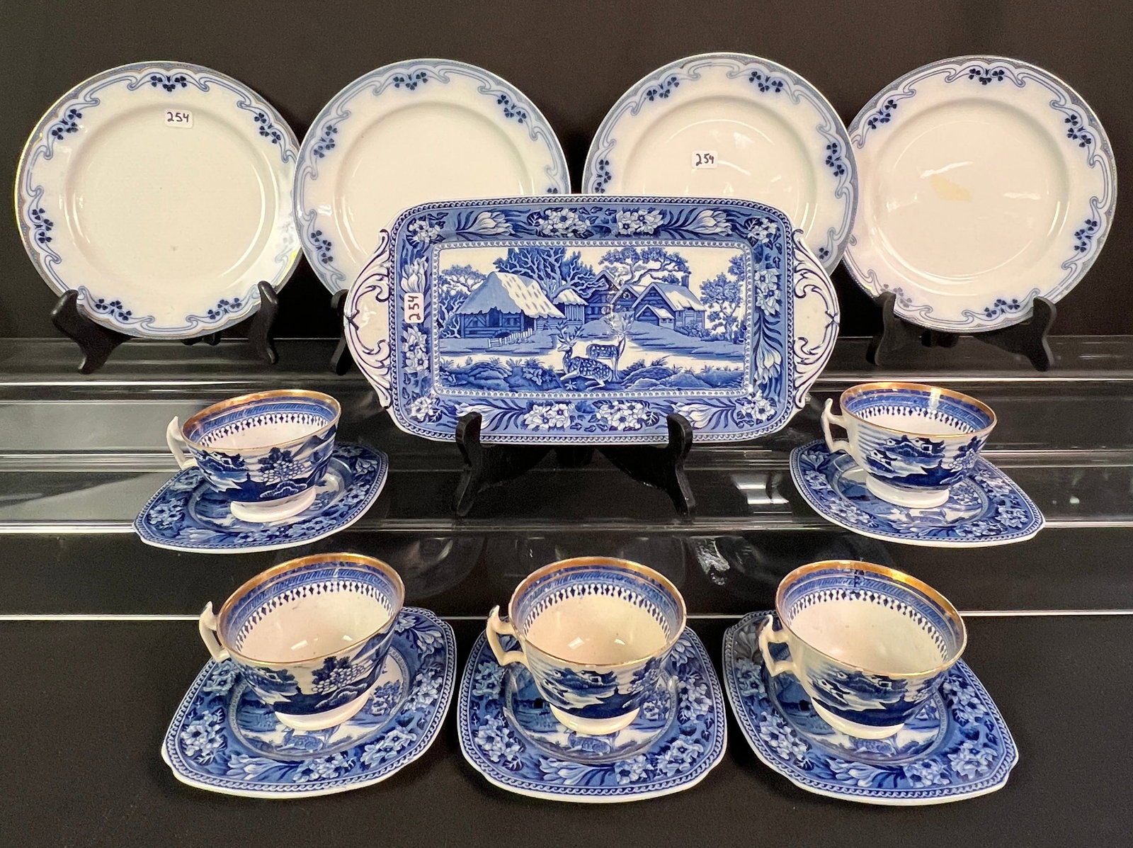 Flow Blue Plates, Teacups, Saucers and Platter: A lot of flow blue to include 4 plates are attributed to W.H. Grindley in the "Iris" pattern, 5 teacups and saucers along with a small platter In the "Fallow Deer" pattern by Wedgwood. Each plate