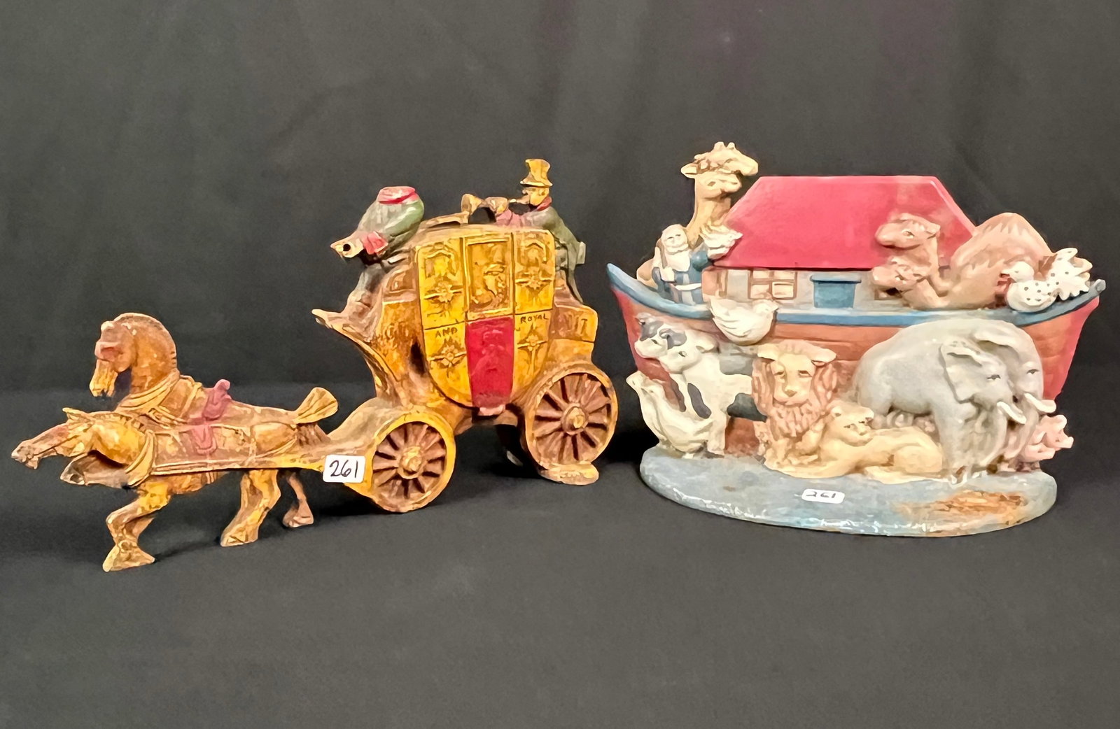 Pair of Figural Cast Iron Door Stops: A pair of figural cast iron doors tops to include vintage Noah's Ark and an antique London mail carriage (one figure has no head)