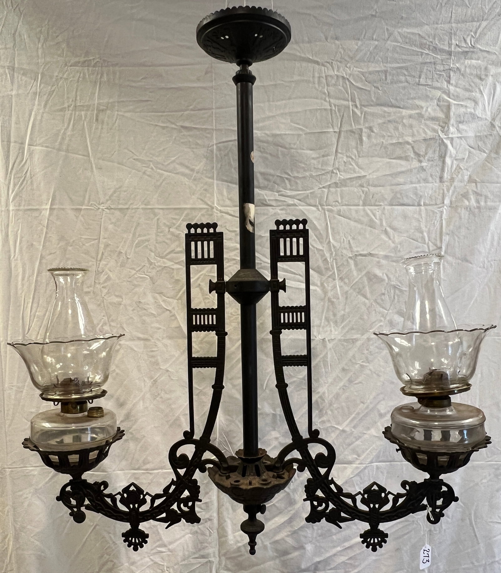 Cast Iron Oil Fixture: A cast iron, double-armed oil fixture with original fonts and shades, fancy frame, in good condition. It measures 33.5" tall X 32" across.