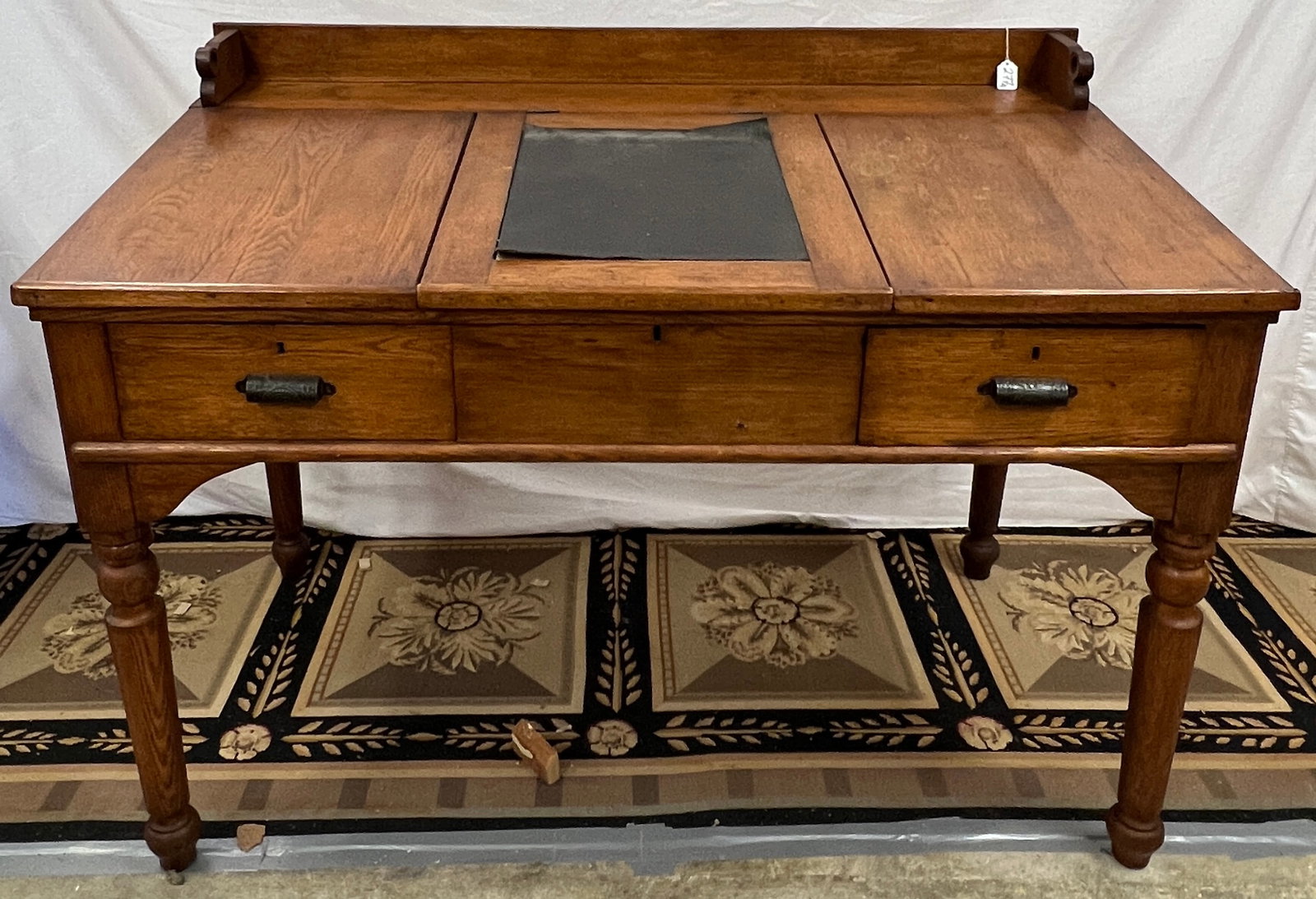 Early Railroad Desk: An early railroad desk purportedly out of the Racine Depot, it has 3 drawers across the front, a lift-top center, with turned legs and gallery back. In original finish, this oak railroad desk measures