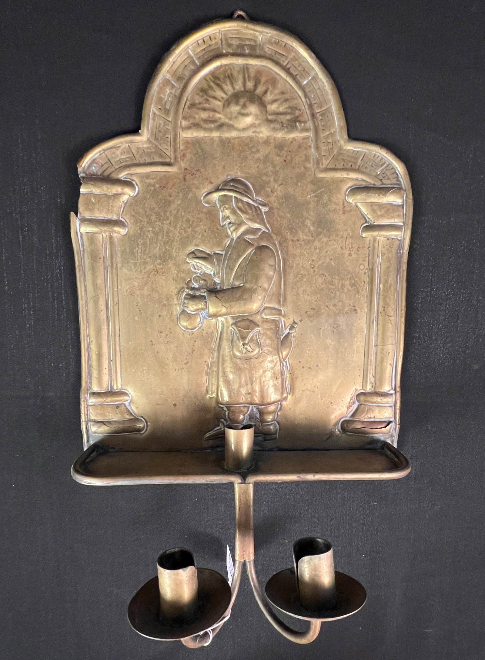 Early Brass 3-Candle Wall Sconce, c.1790-1810: An 1790-1810 early brass 3-candle wall sconce, all hand done, depicting a traveling salesmen with sun above his head. One minor loss on left side, but in overall great condition for its age. It measur