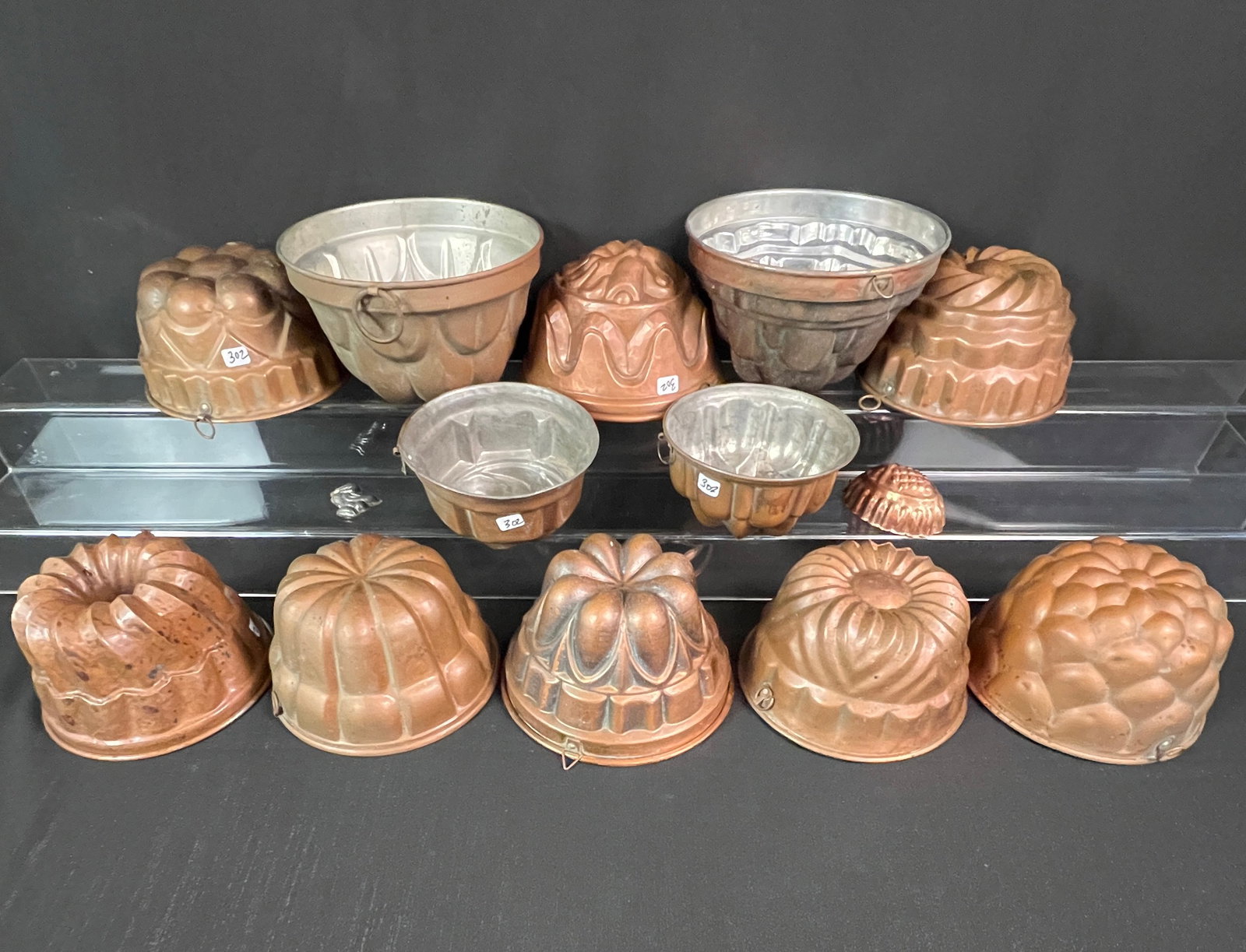 12 Vintage Round Copper Molds: A group of 12 handmade copper food molds in excellent condition that each approximately measure 4.5" tall X 7.5" across