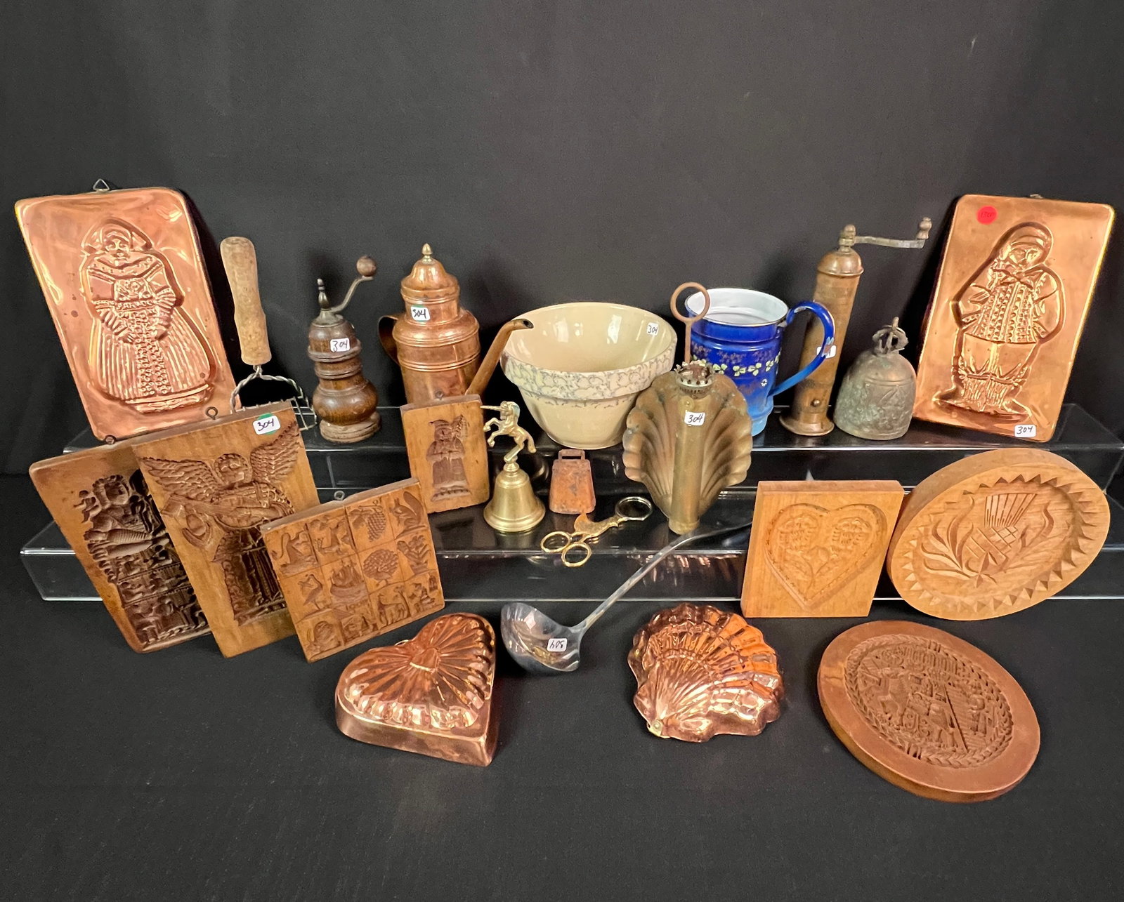 Group of Antique and Vintage Farm Kitchen Items: A large group of vintage and antique farm kitchen items to include 7 cookie molds, floral enamel strainer, Roseville spongeware bowl, copper pepper grinder, brass bells, copper pudding molds, Copper