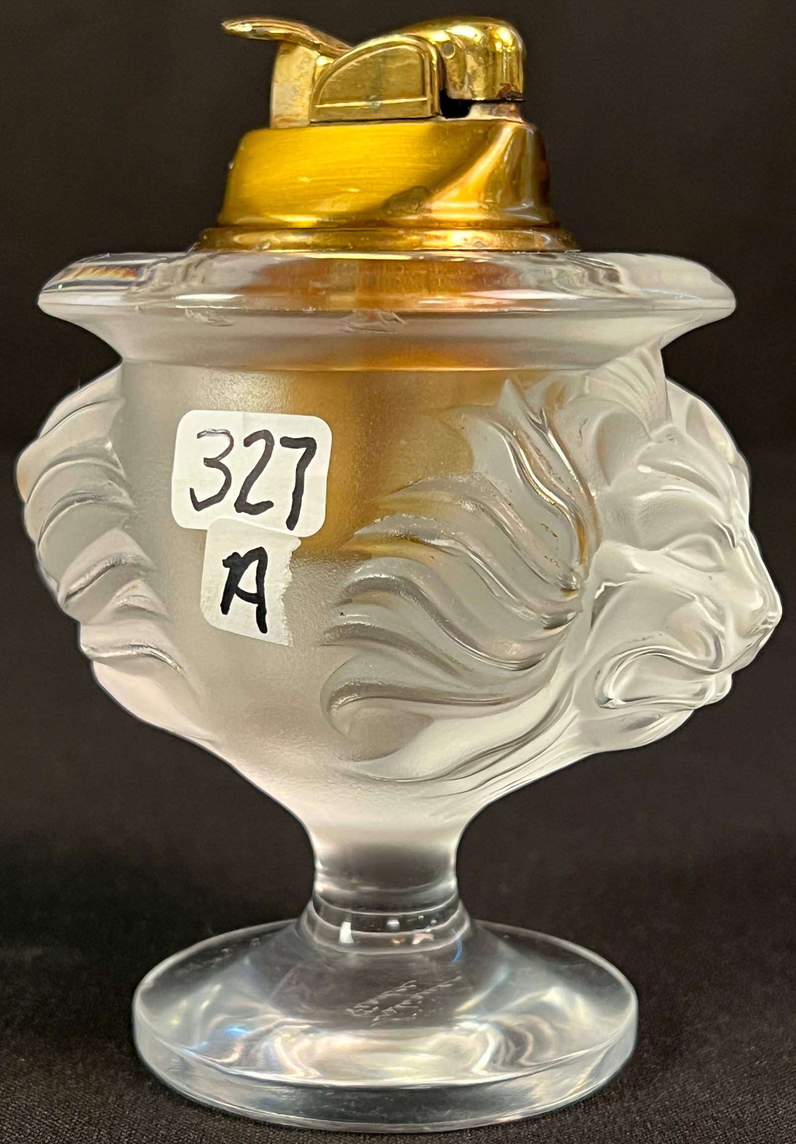 Lalique Lion Head Table Lighter: A Lalique France double sided lion head table lighter. In excellent condition, it measures 4" tall X 3.5" across.