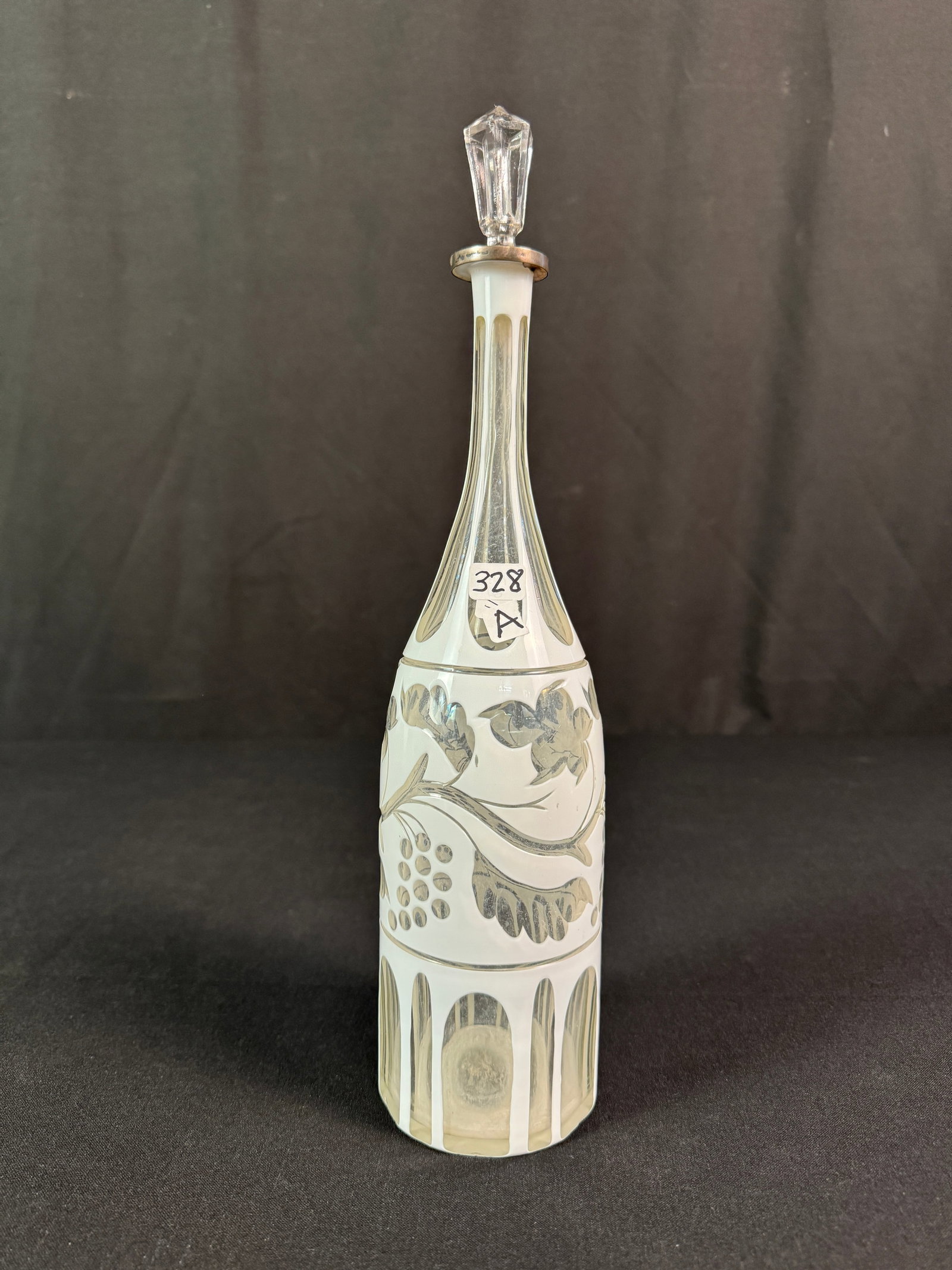 Layered Cutback Early Decanter: An early crystal cream cut to clear decanter depicting grapes and grapevines. It retains its original silver trimmer crystal stopper, c.1880/90. In excellent condition, it measures 13.5" tall.