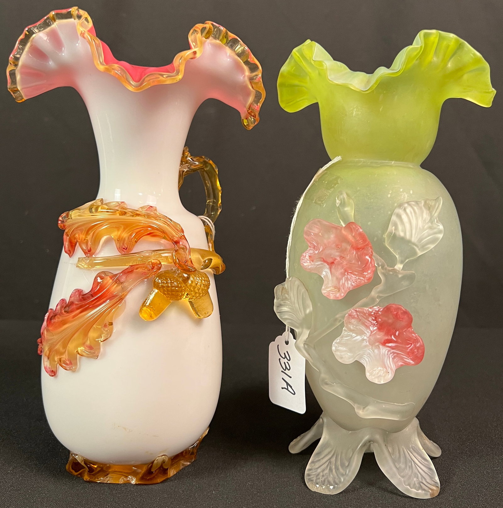 Two Victorian Art Glass Vases: Two hand-blown Victorian art glass vases, one in satin green with applied flowers and ruffled edge and fluoresces (8.5" tall X 5" across). The second is a pink and white, ruffled edge, case glass vase
