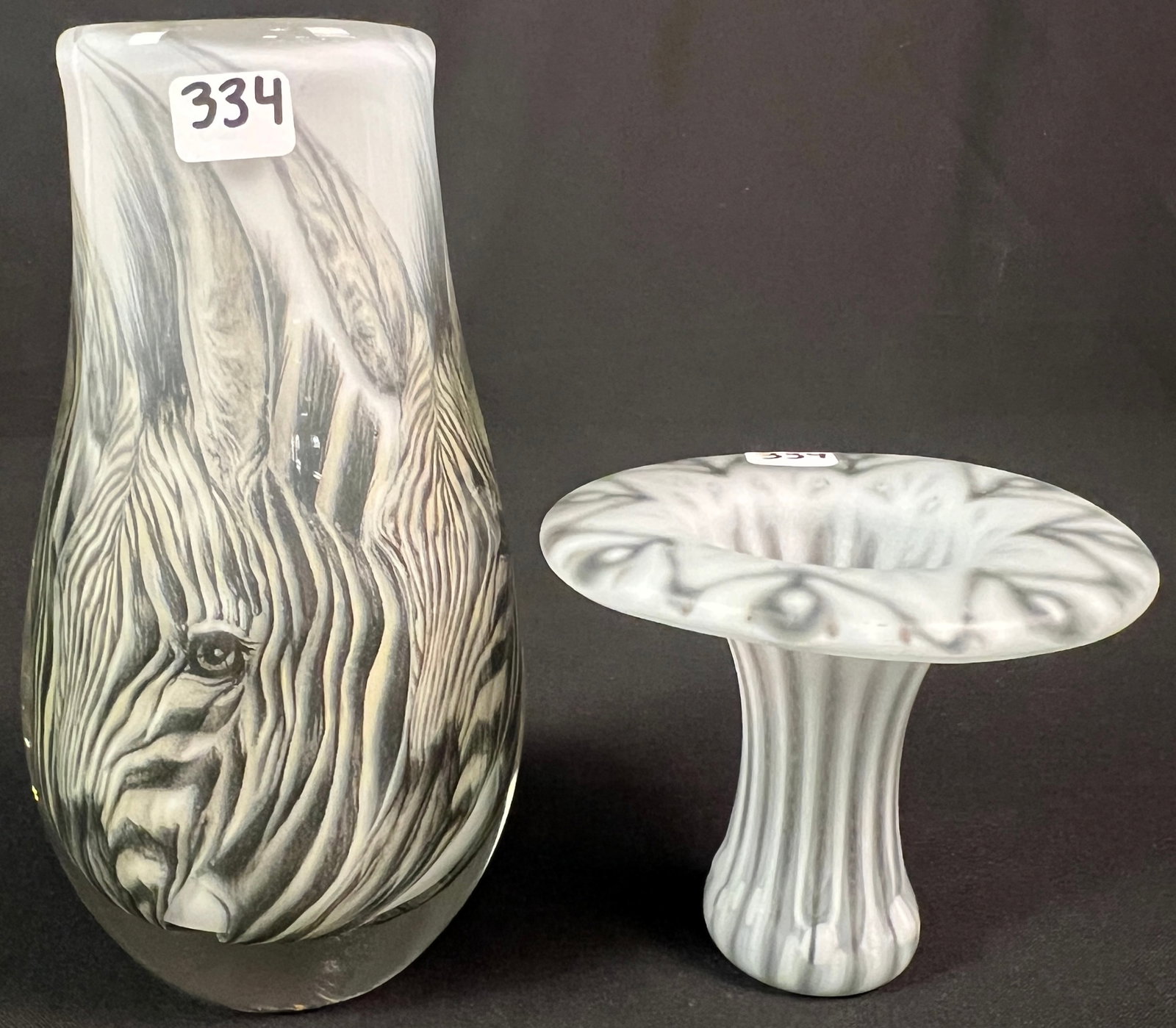 Two Signed Vintage Art Glass Vases: An "African Dream" signed art glass depicting zebras, vase is signed "Toan 1982" and measures 7" tall. Also included is a signed Higgins 1950s dropout vase by Michael & Frances Higgins measuring 3.5" 