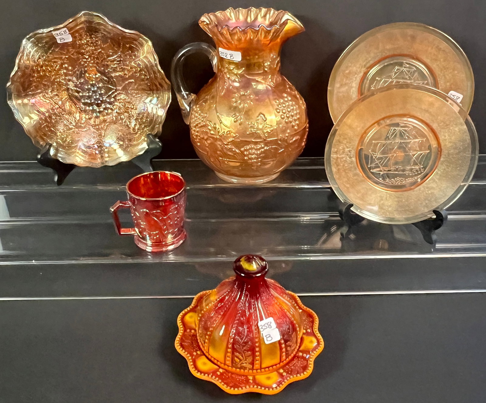 Merigold Carnival Glass Lot: A group of 6 carnival glass Merigold pattern items to include 4 antique and 2 new. The antique pieces include grapevine lemonade pitcher with ruffled edge (9.5" tall X 8" across), grape cluster plate/