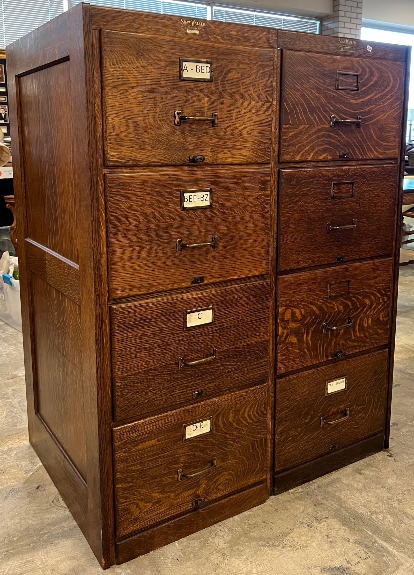 Two Section Eight-Drawer Oak Filing Cabinet: Shaw Walker Muskegon, MI double section, eight drawer oak filing cabinet with chamfered sides and original finish. It measures 52" tall X 40" across X 27" deep.