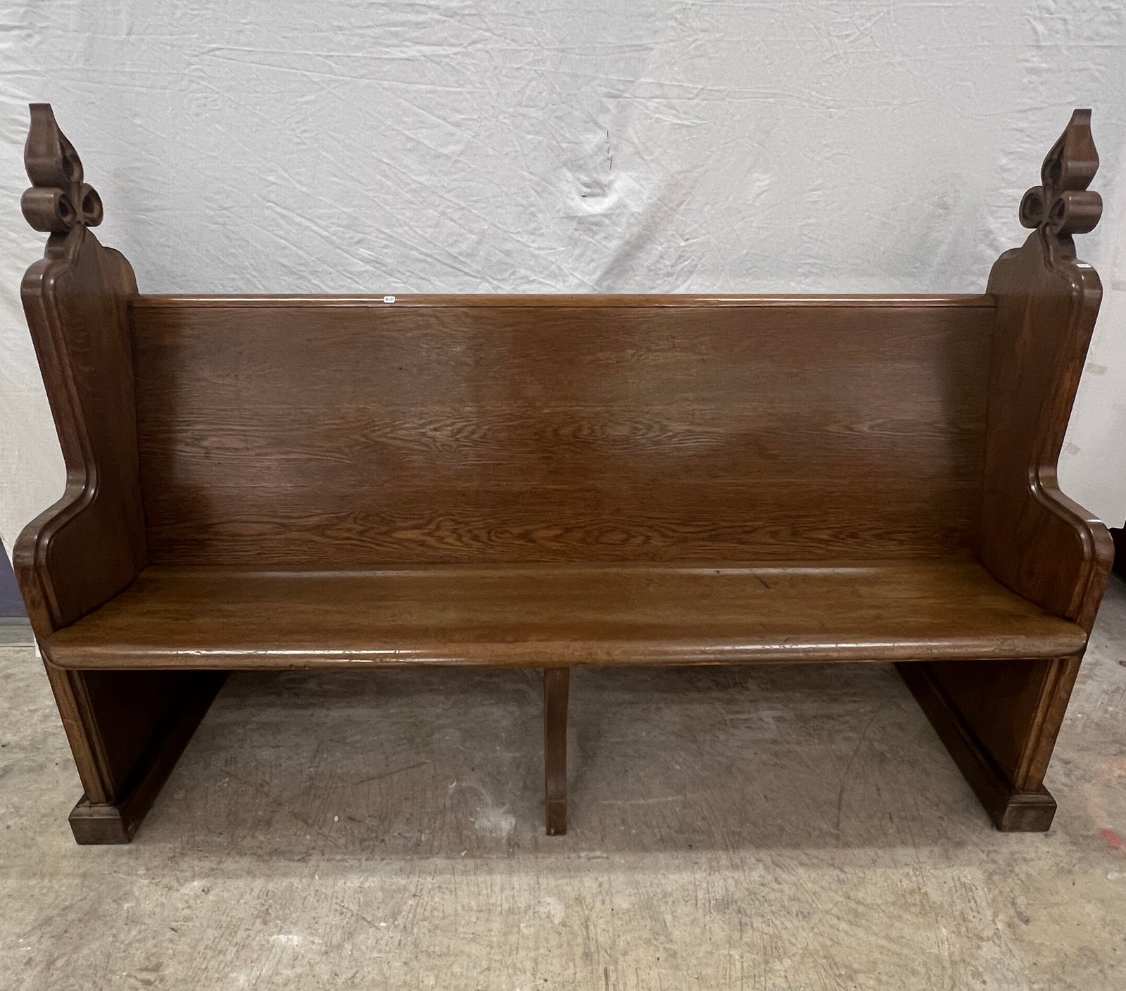 Fancy Church Pew: A fancy oak church pew with pierced carved fleur de lis tops and gothic paneled sides. In original finish and good condition, it measures 46.5" tall X 66.5" across X 14.5" deep.