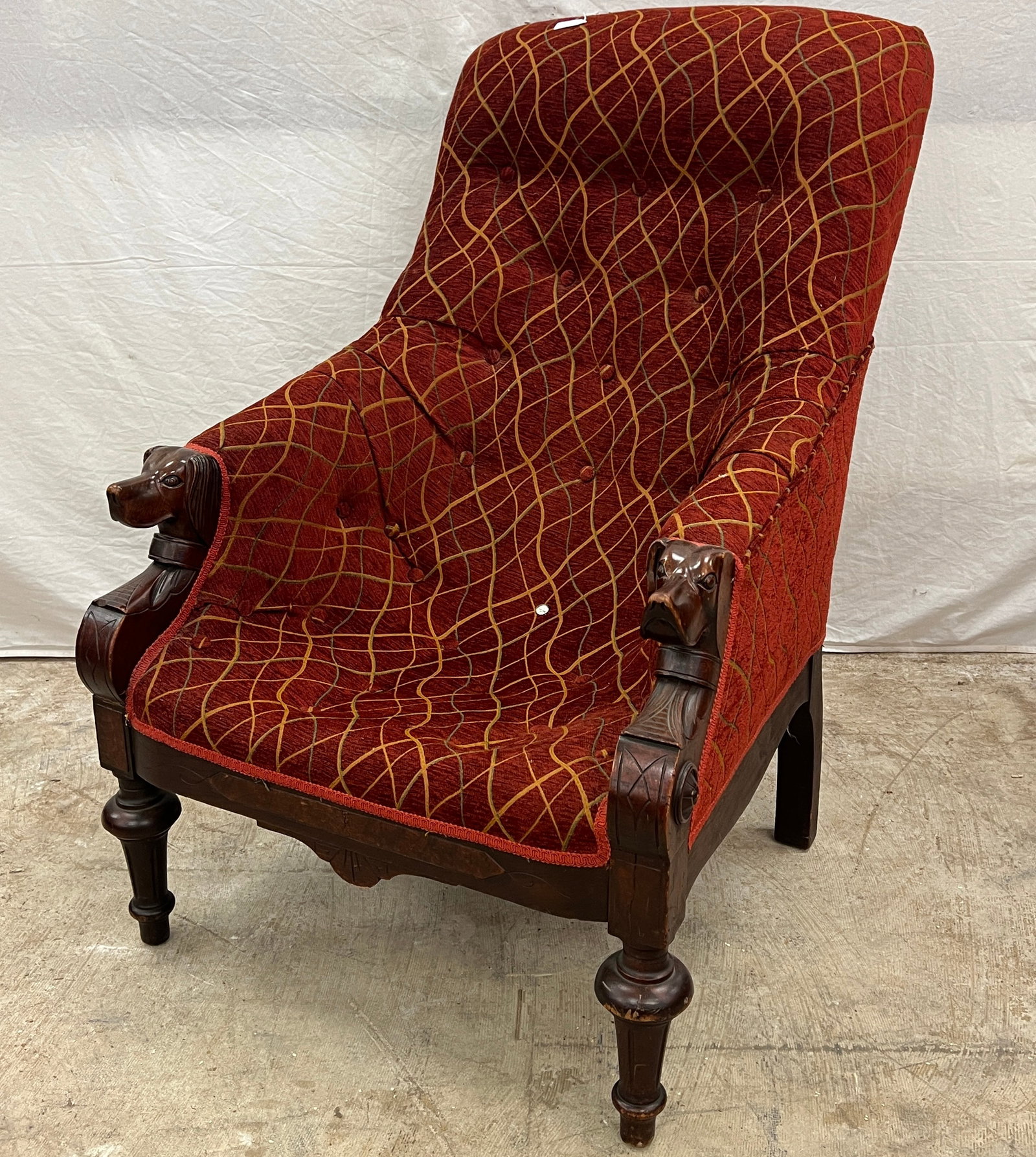 Victorian Dog Head Armchair: A Victorian club oversized armchair with carved dog's heads in walnut. This unusual armchair appears to be newly upholstered. In house ready condition with missing ear to one dog head, it measures