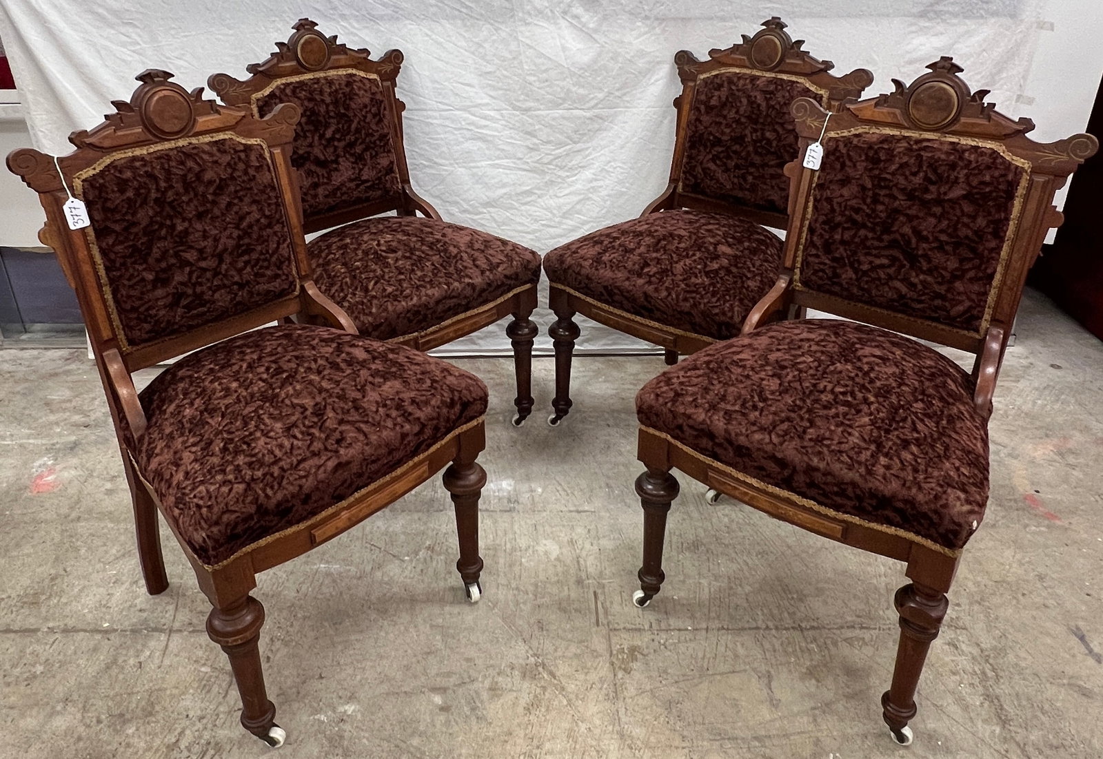 Four Victorian Parlor Chairs: Four quality Victorian parlor chairs with elaborate burled panels, fancy backsplash, with turned legs on original white porcelain castors, in original condition. Losses noted to the turned legs. They 
