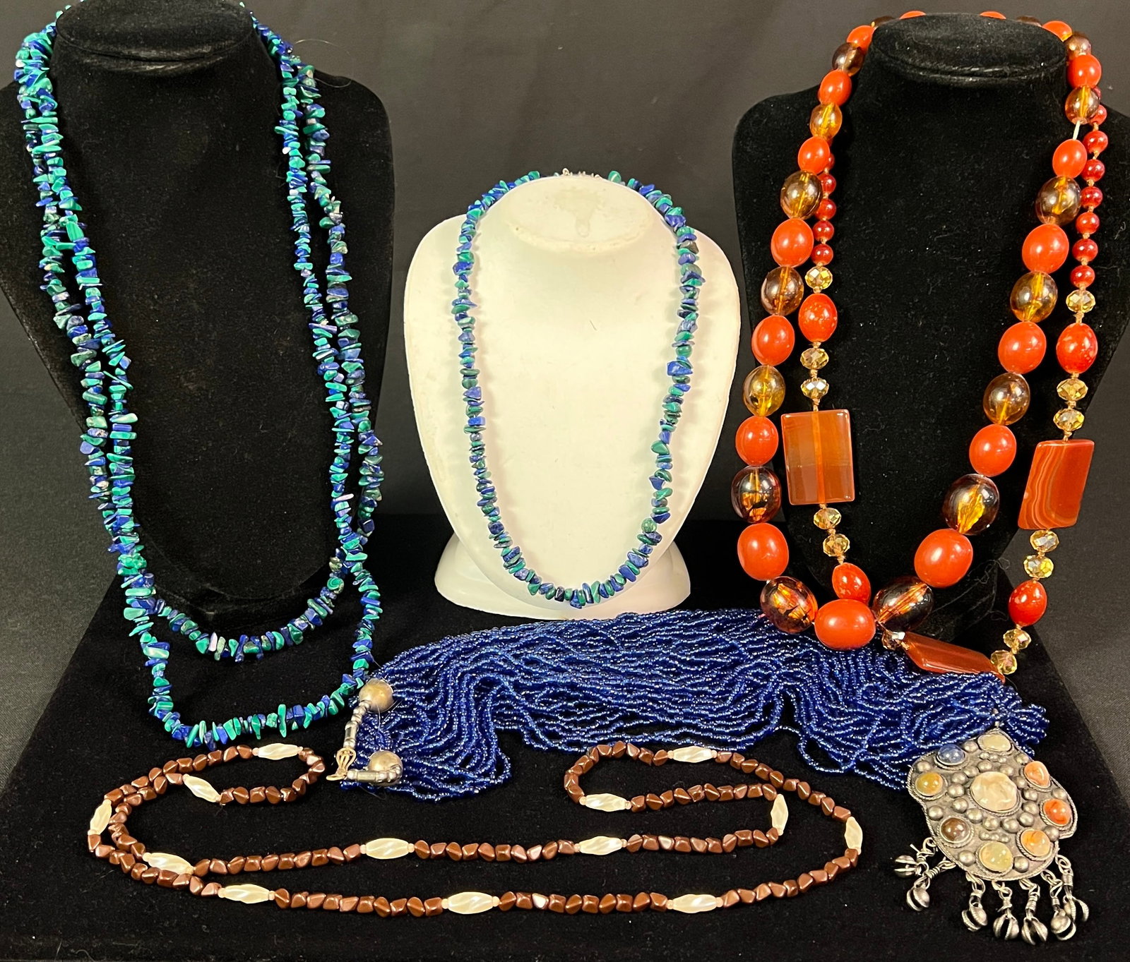 Necklaces to Include Garnet, Malachite, Ethnic & More: A lot of various necklaces to include a silver and semi-precious stone pendant blue beaded necklace (27" long), 3 malachite and lapis necklaces (17.5" long, 28" long, 24" long), 2 carnelian and