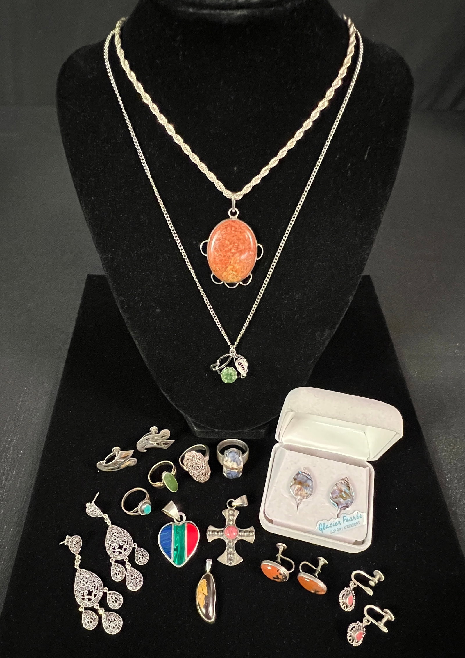 Sterling Lot: A sterling lot to include sterling and green stone pendant necklace, a pair of glacier pearl and sterling clip on earrings, a sterling and sodalite ring (sz 8), a sterling rope chain with red speckled