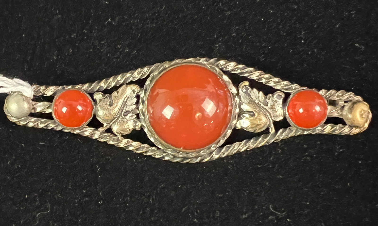 Carnelian & Sterling Brooch: A carnelian and sterling brooch with leaf and rope details. In great condition, it measures 3.25" long X 1" wide.