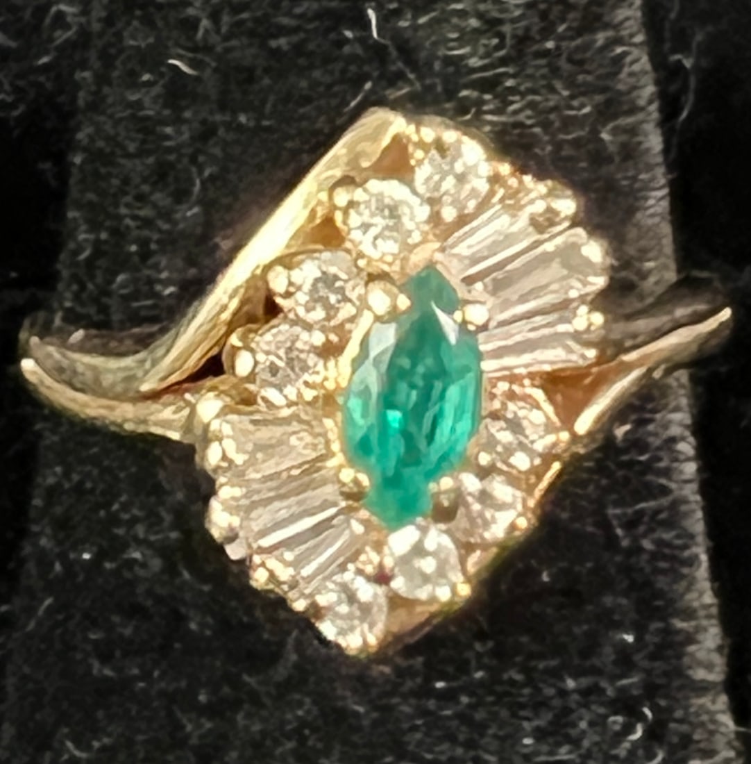 Emerald and Diamond 14k Ladies Ring: A 14k ladies ring featuring a marquise cut emerald surrounded by baguette and circular diamonds. Ring weighs 4.33 grams and is a size 7 (6.5 with sizer).